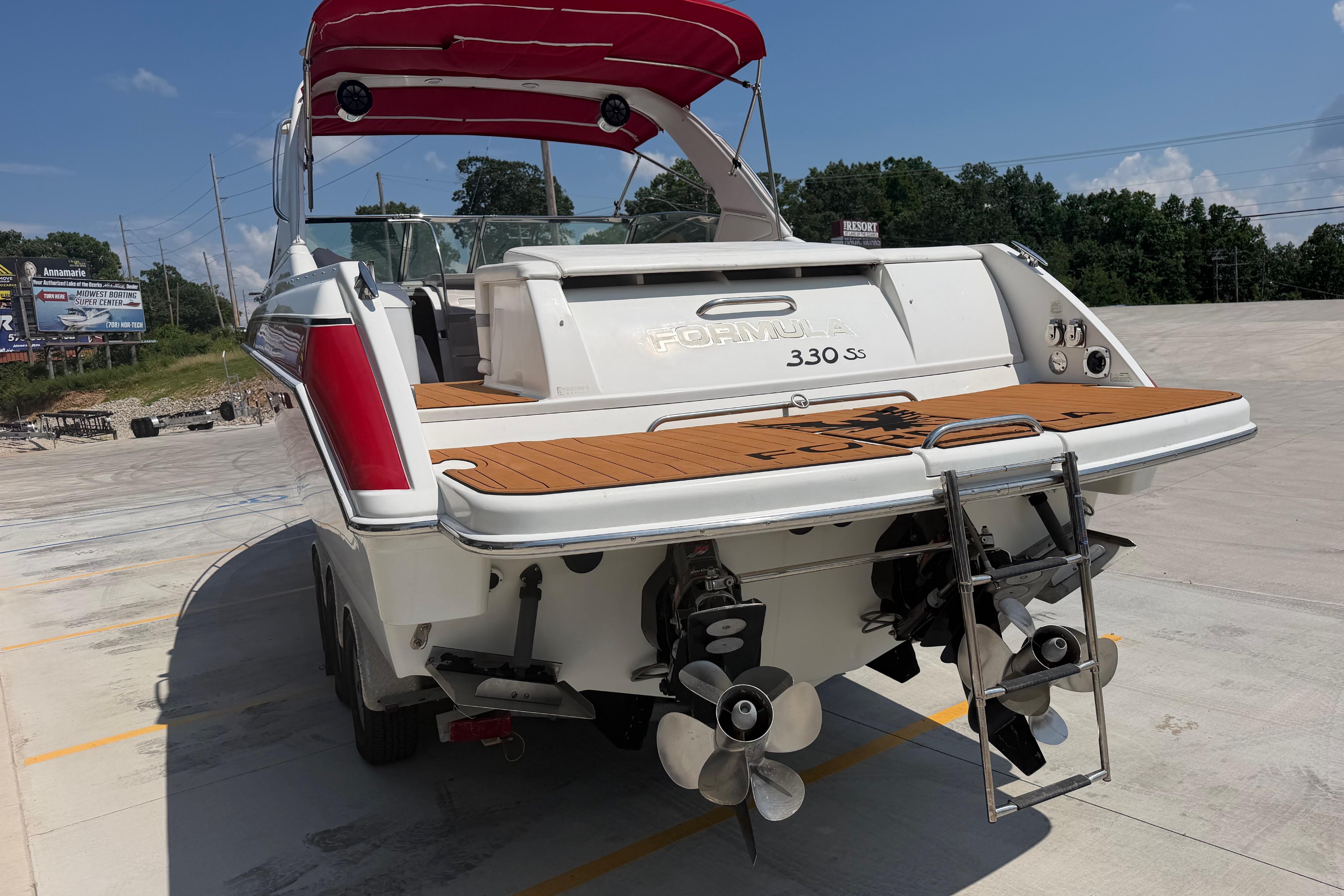 2006 Formula 330 Sun Sport boat with dual propellers and swim platform, parked outdoors.