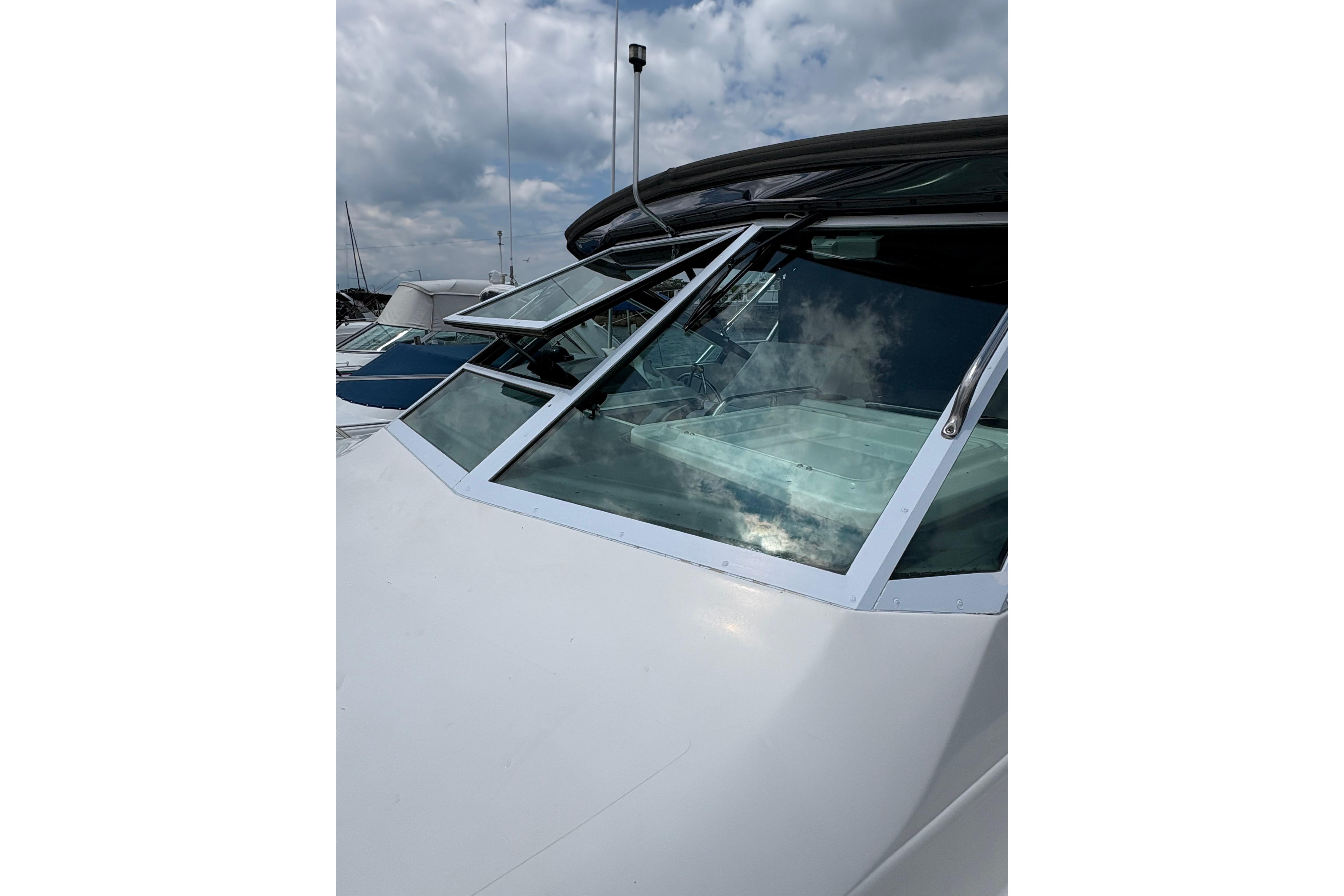 1999 Tiara Yachts 3100 Open boat with sleek windshield design under cloudy sky.