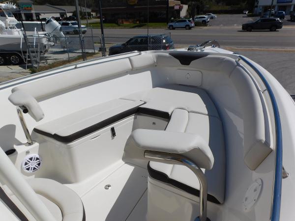 2024 Sailfish 242 CC boat interior with white cushioned seating and storage compartments.