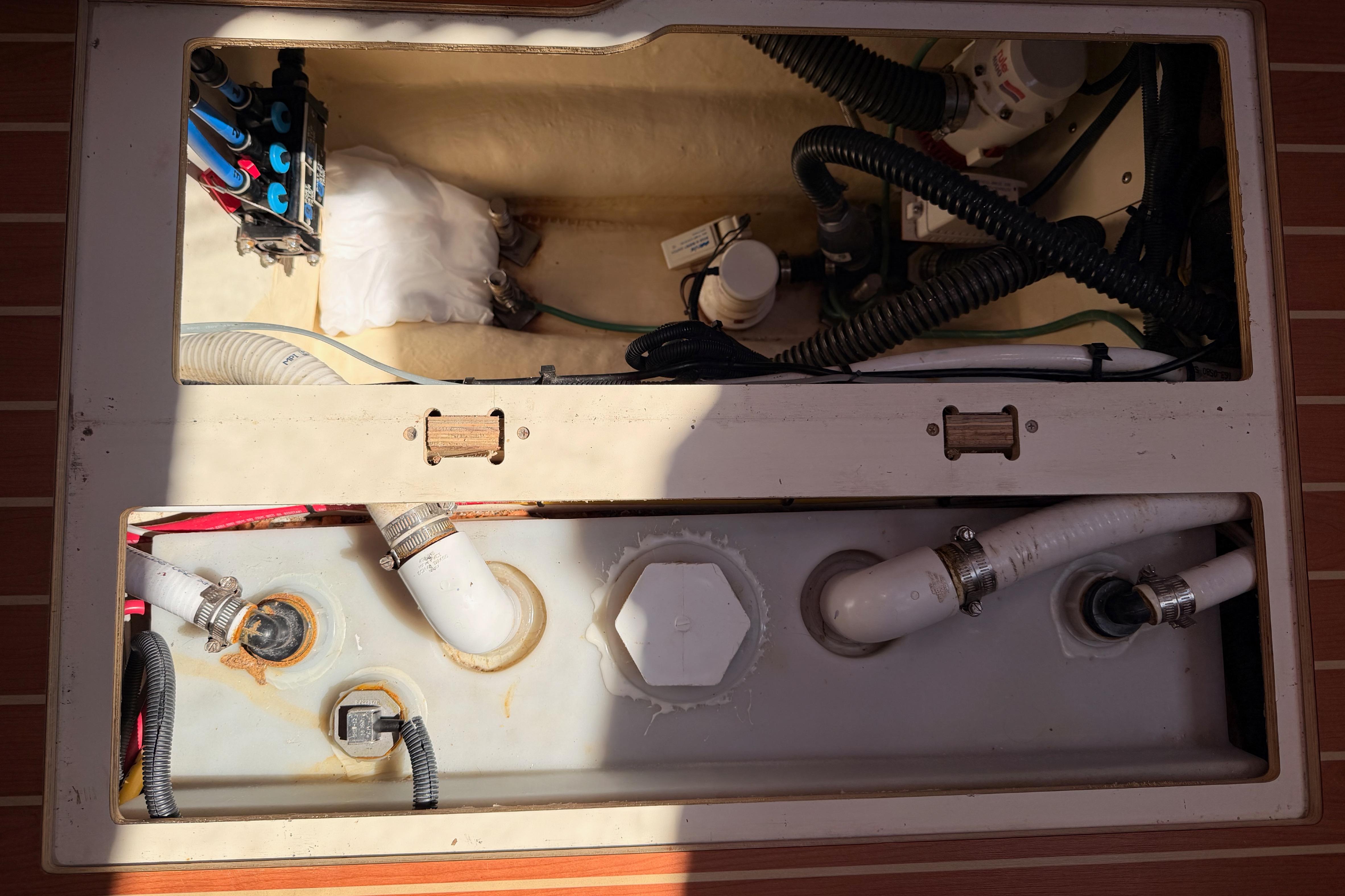 Engine compartment of a 2008 Hunter 45 Deck Salon sailboat, showing hoses and wiring.