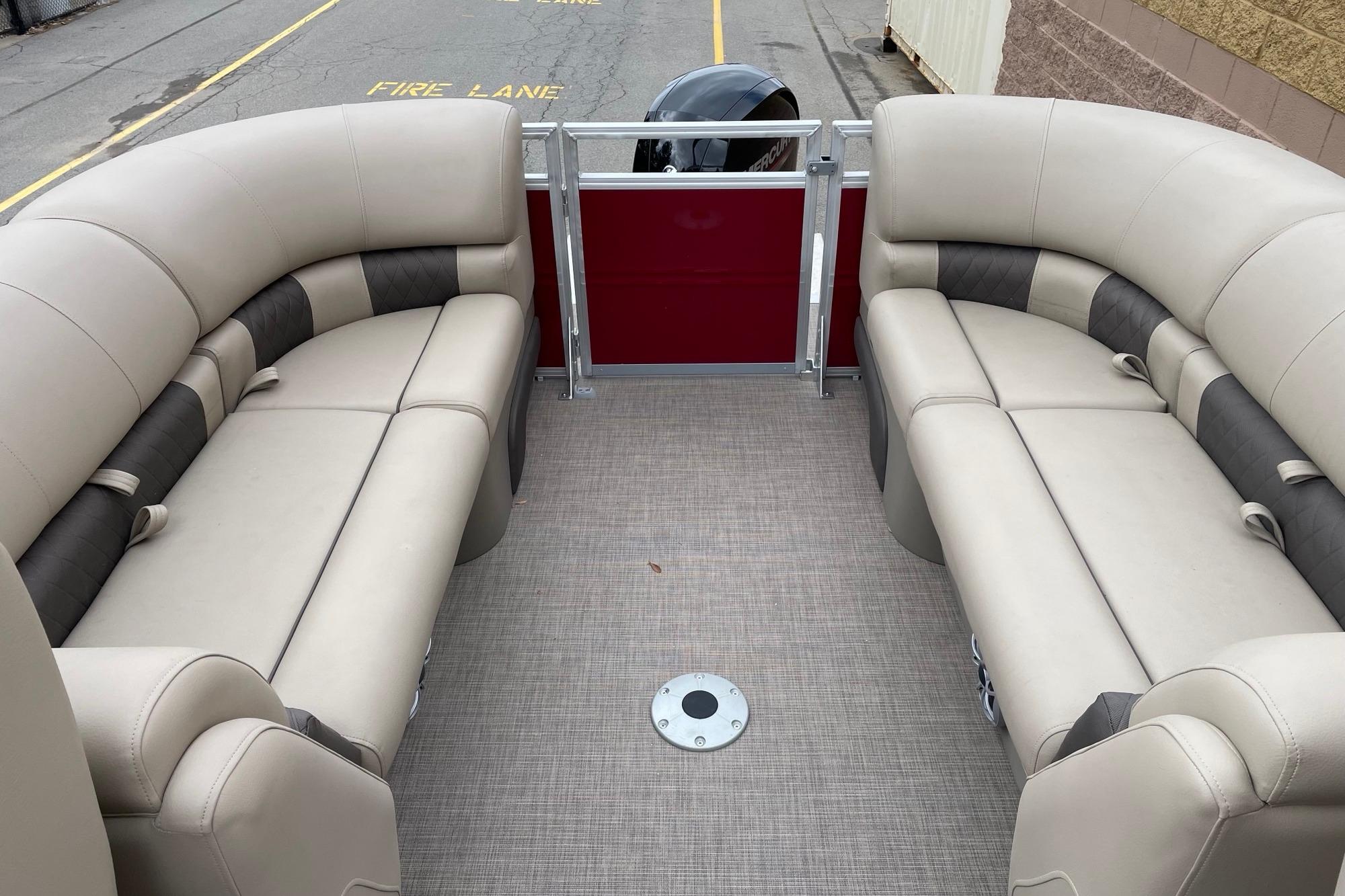 2025 Sun Tracker Party Barge 22 XP3 interior with beige seating and red panel.