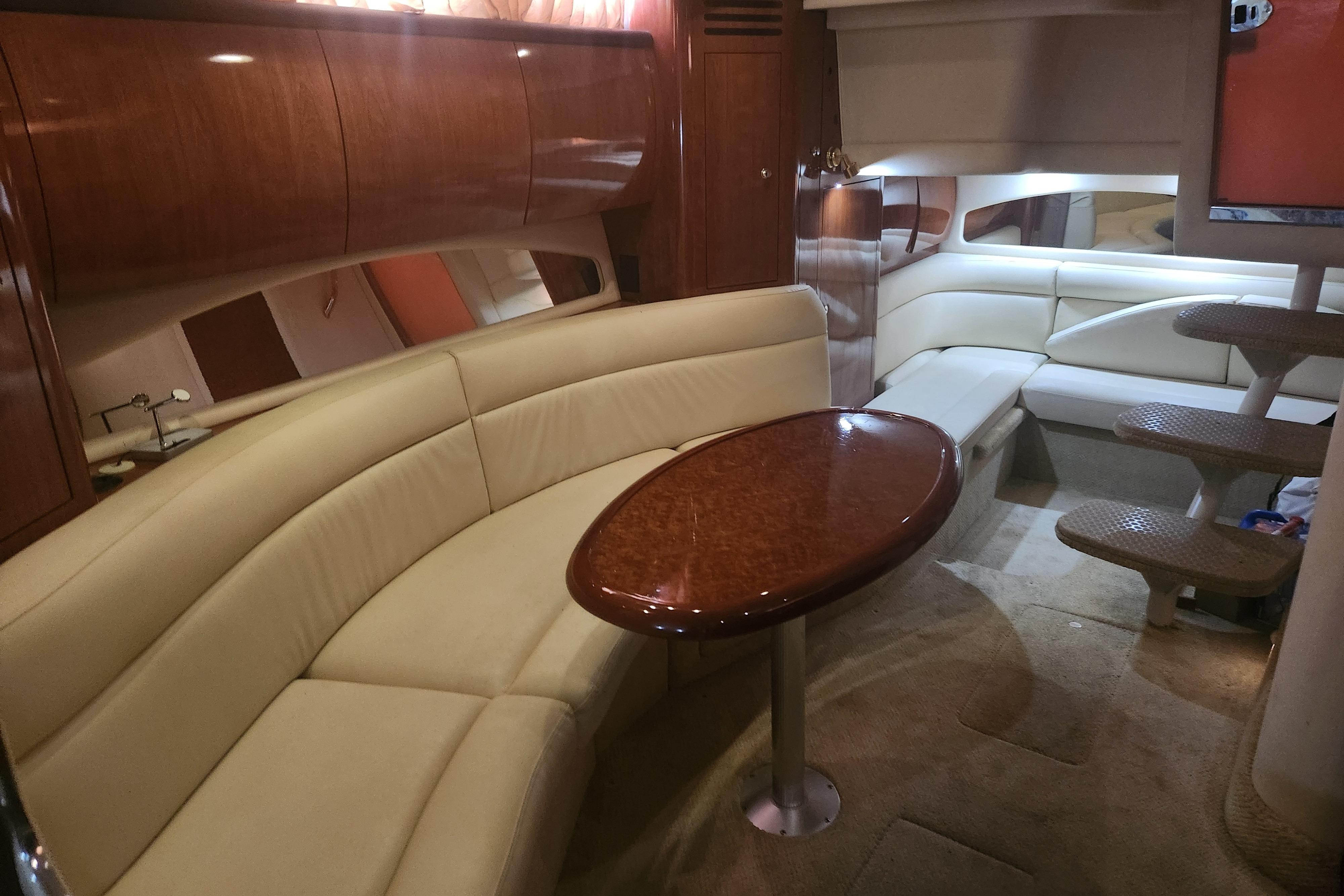 Luxurious interior of a 2003 Sea Ray 360 Sundancer yacht with elegant seating and wooden table.