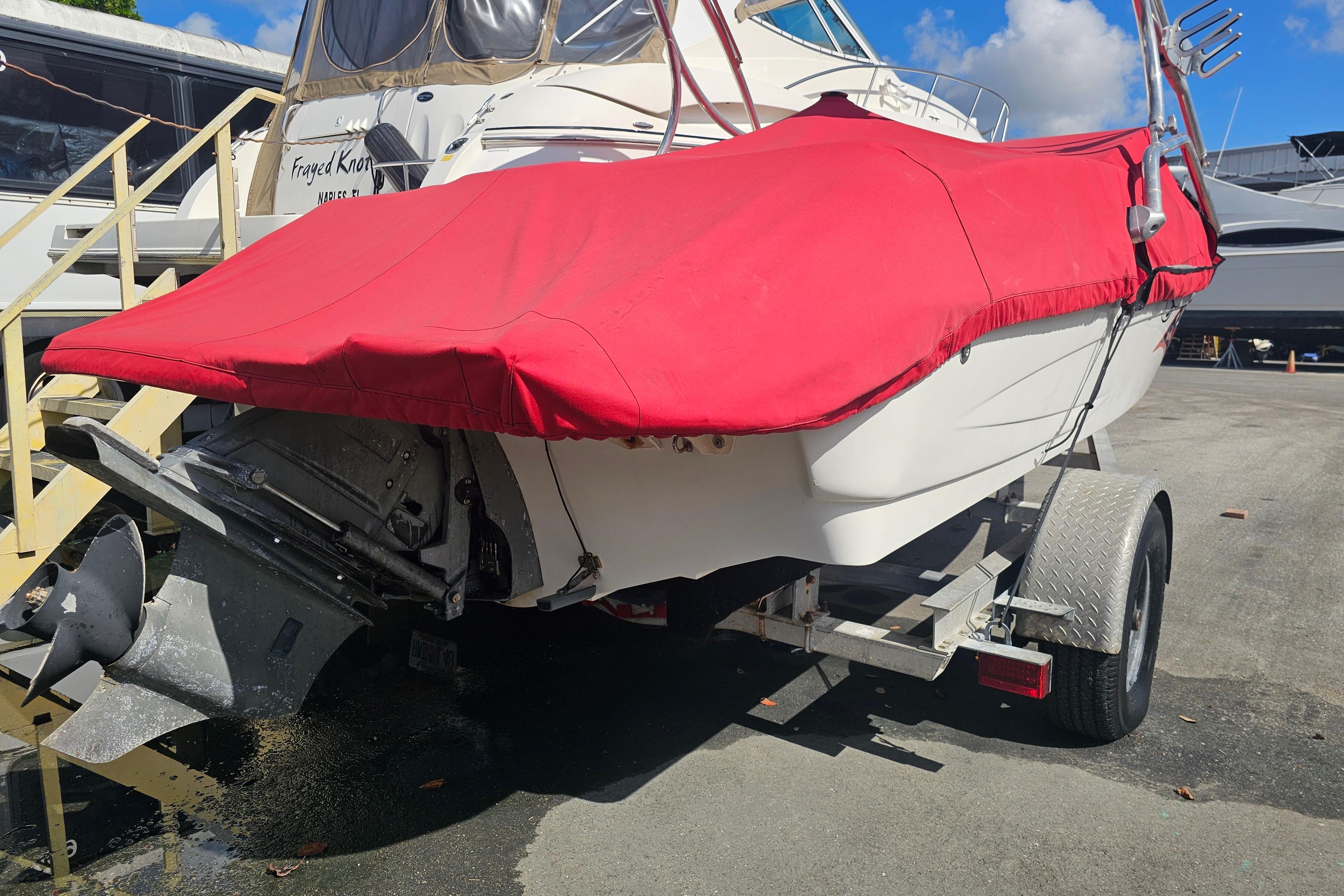 2008 Glastron GT 205 boat with red cover on trailer, parked outdoors.
