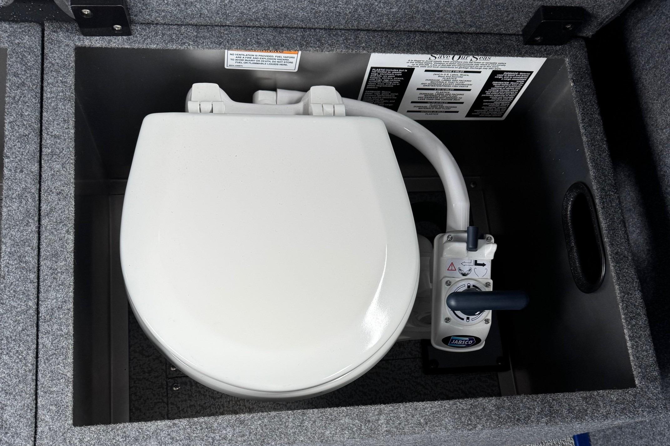 2024 Spartan 26 Maximus Pro XL marine toilet with manual pump in a compact compartment.