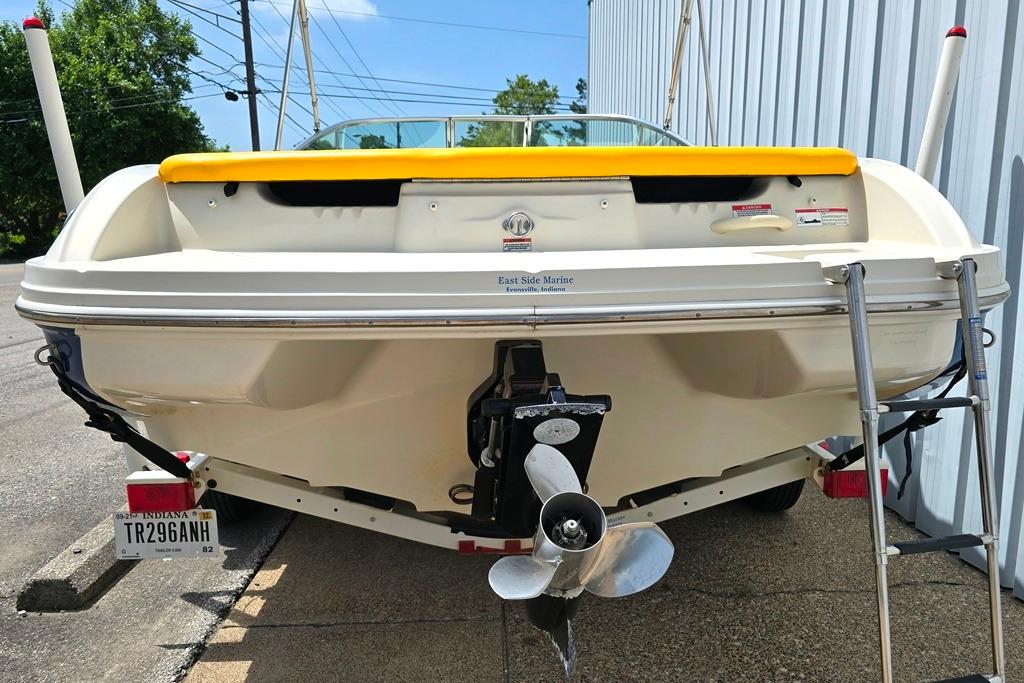 2007 Sea Ray 205 Sport boat with yellow trim, parked on a trailer.