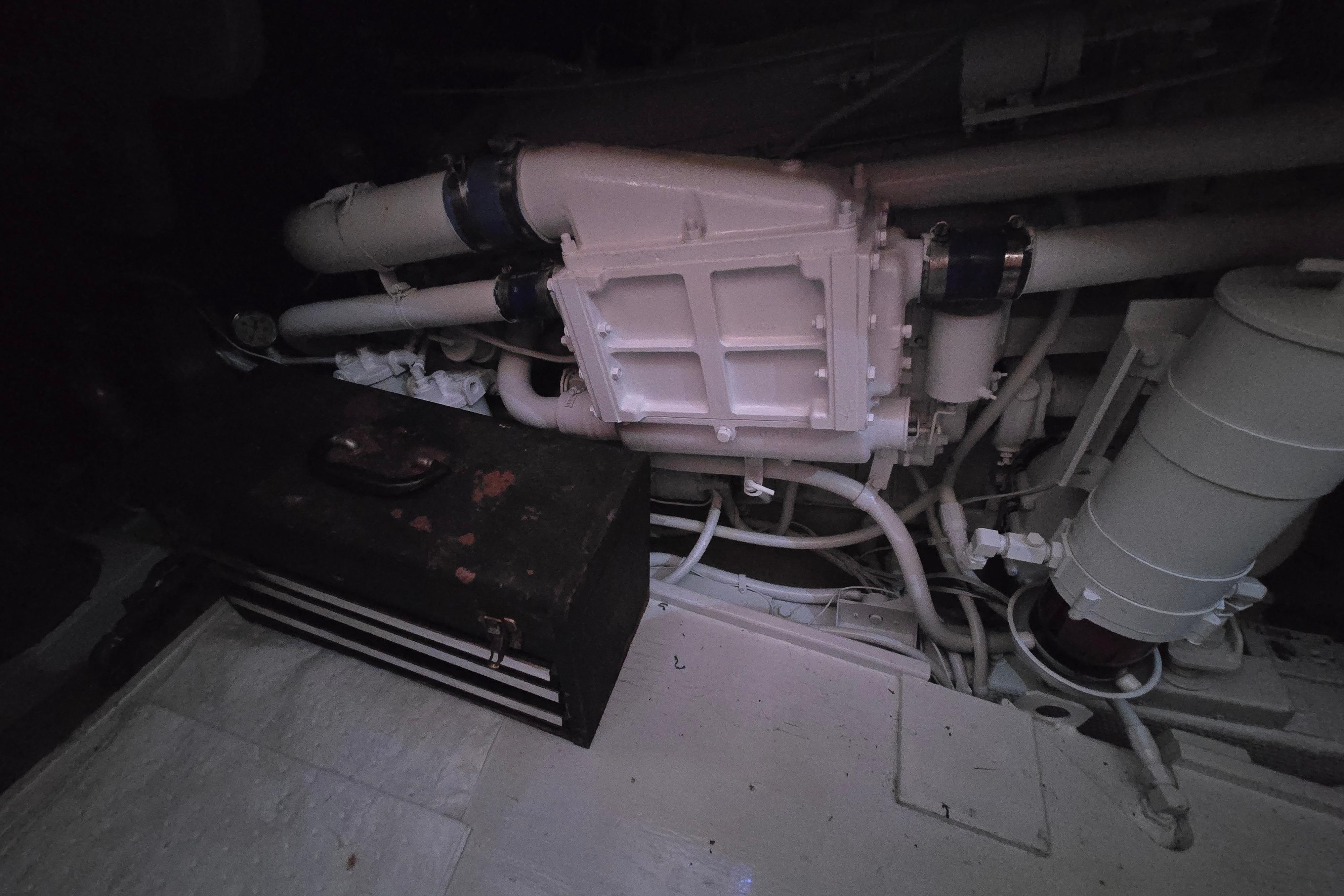 Engine room of a 1988 Post 46 Convertible boat, featuring pipes and machinery.