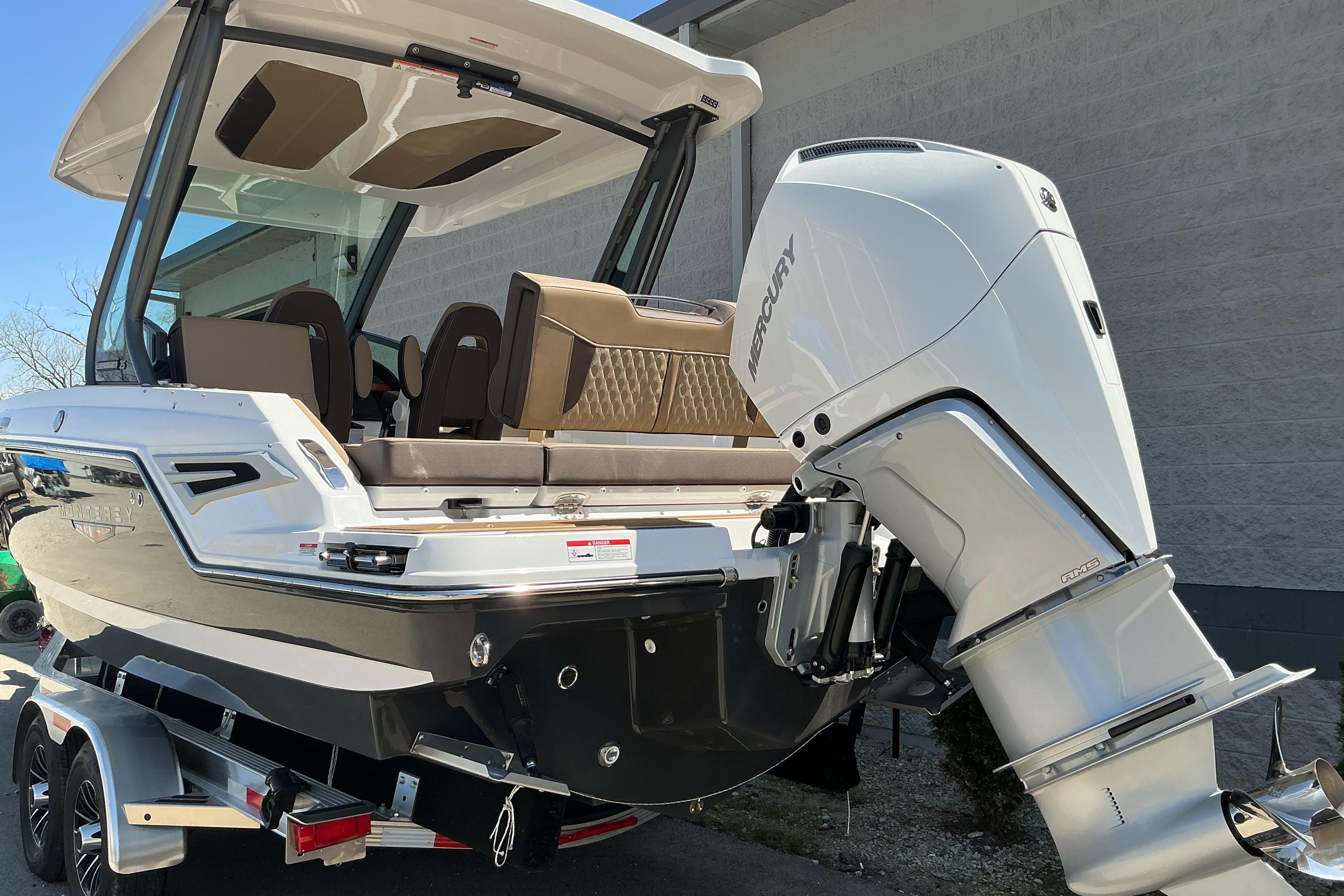 2026 Monterey Elite 25 OB boat with Mercury outboard motor, parked on a trailer.