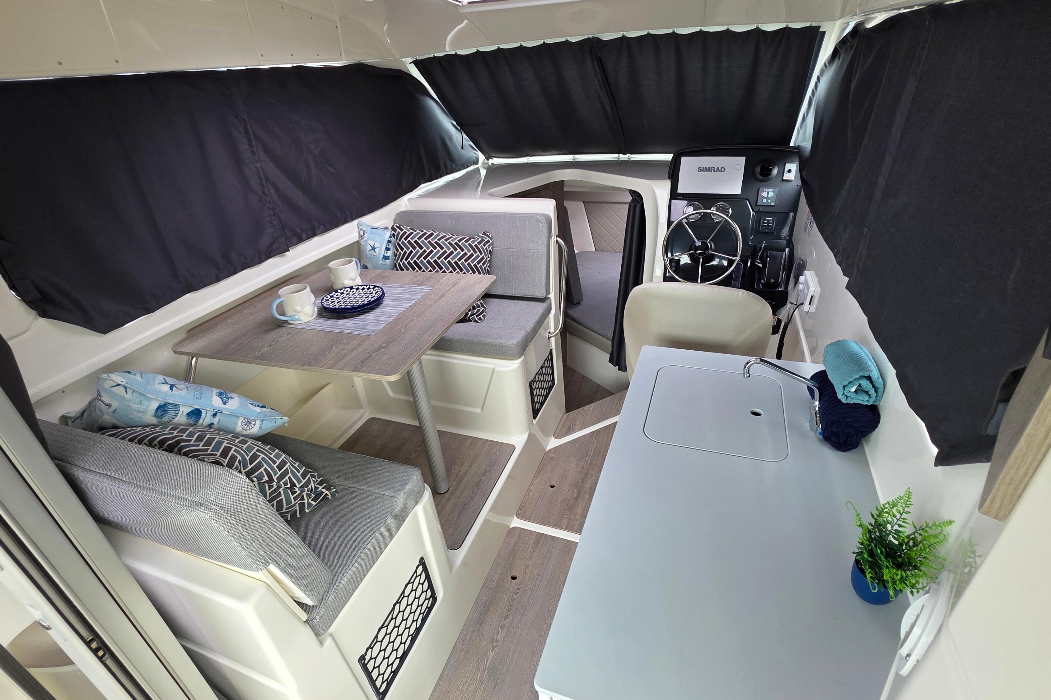 Interior of 2026 Trophy T25EX EXPLORER OB boat with seating, table, and helm.