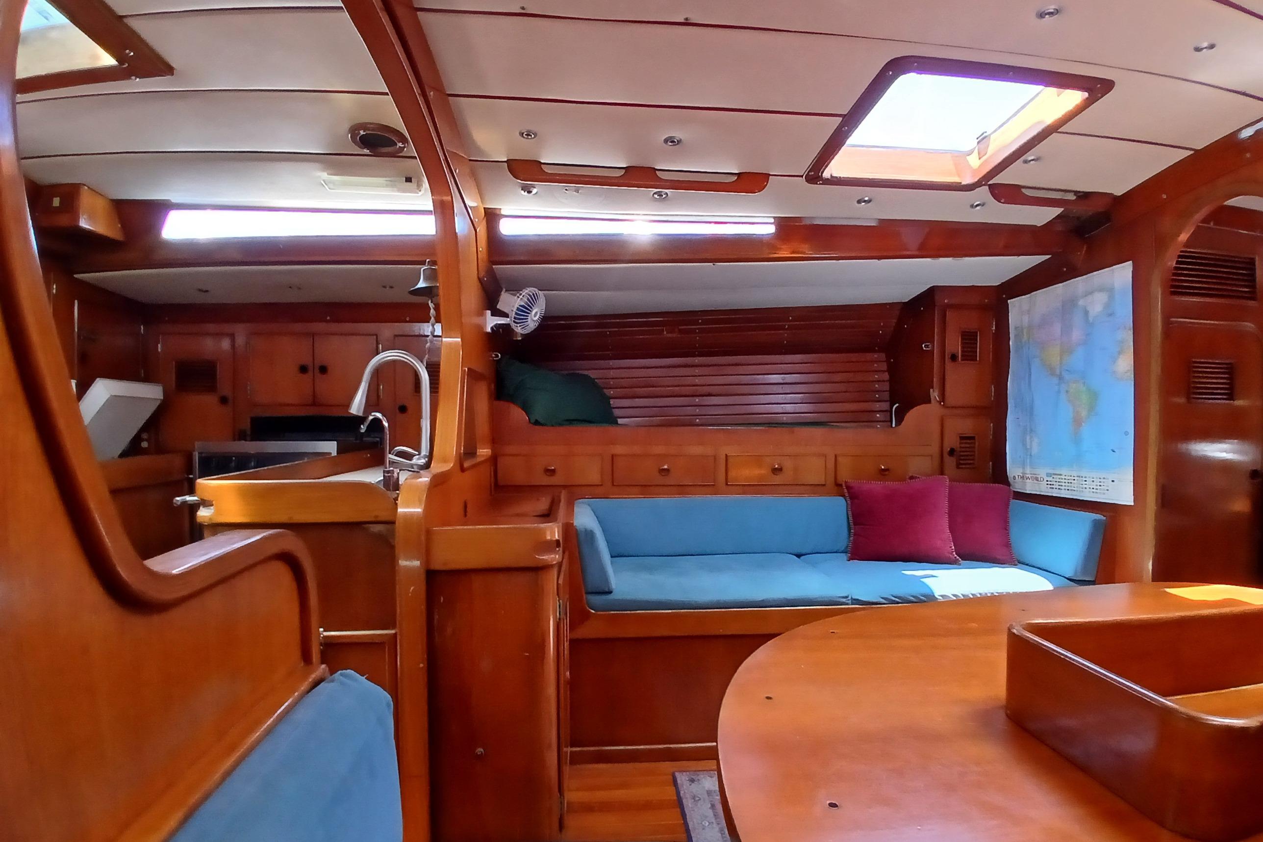 Interior of 1981 SKYE 51 yacht with wooden furnishings and blue seating.