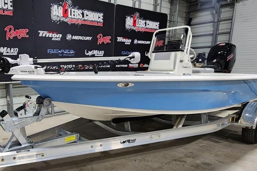 2026 Mako 18 Pro Skiff boat on trailer in showroom setting.