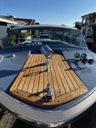 1985 Century Coronado Cardel boat with wooden deck and chrome spotlight.