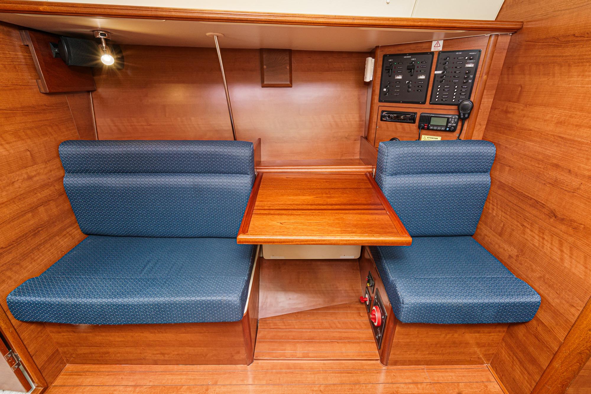 2015 Hunter 33 yacht interior with wooden table and blue cushioned seating.