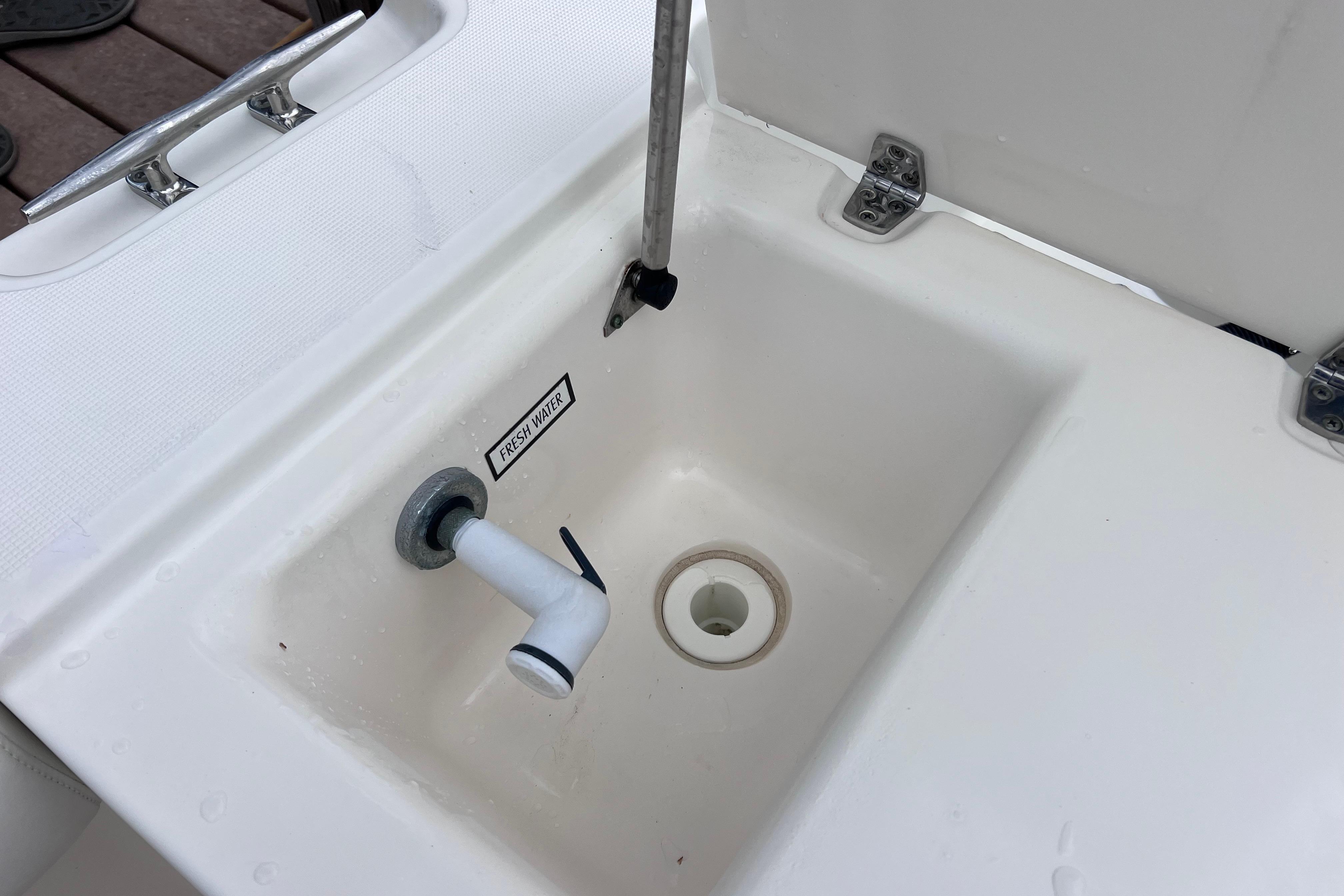 Freshwater sink on 2005 Pursuit 3070 Offshore boat, featuring a clean white basin.
