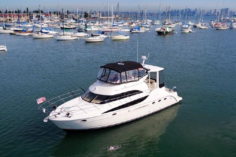 2004 Meridian 459 Motoryacht cruising in a marina with numerous sailboats.
