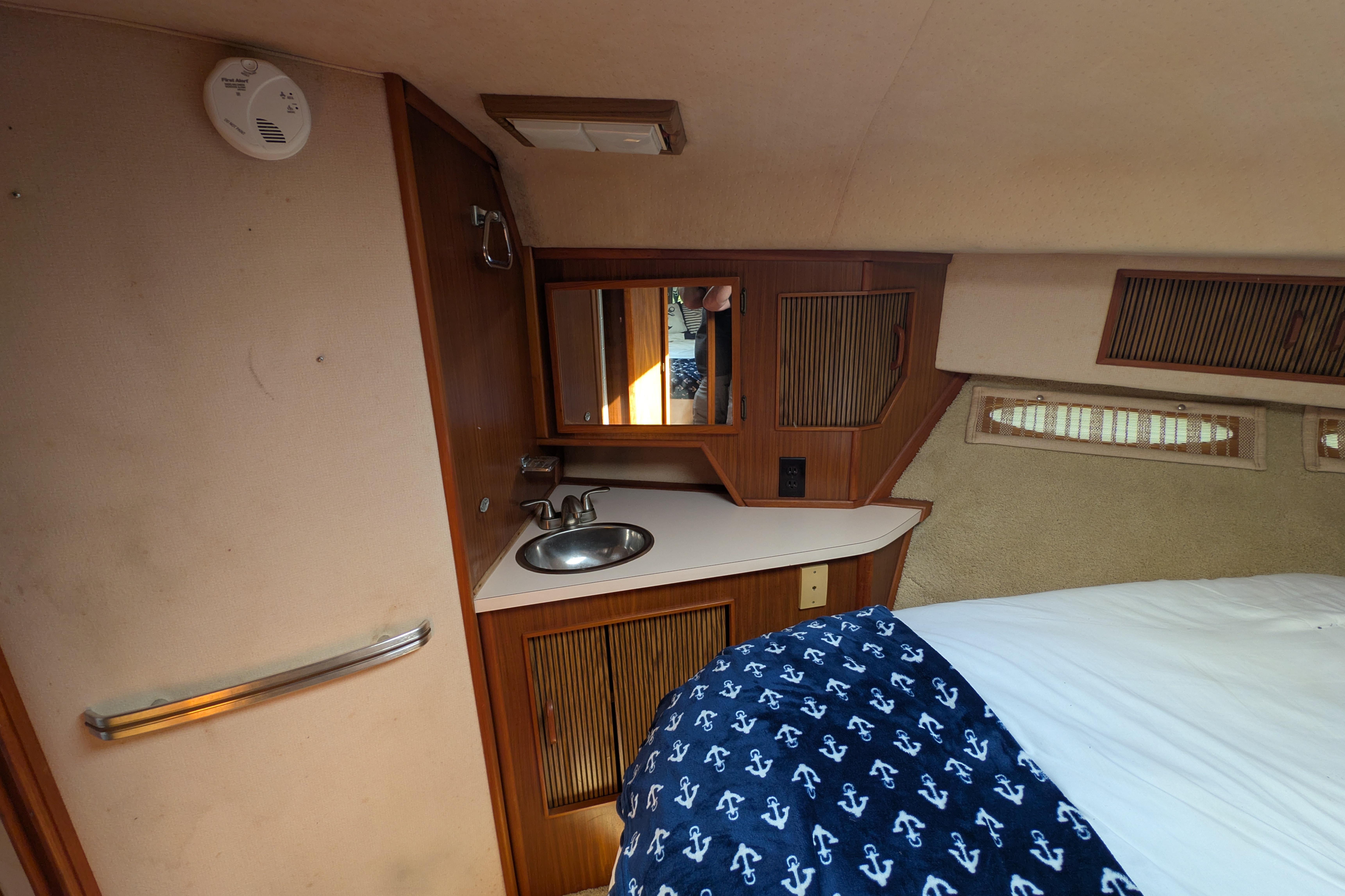 1987 Sea Ray 390 Express Cruiser cabin interior with sink and bed.