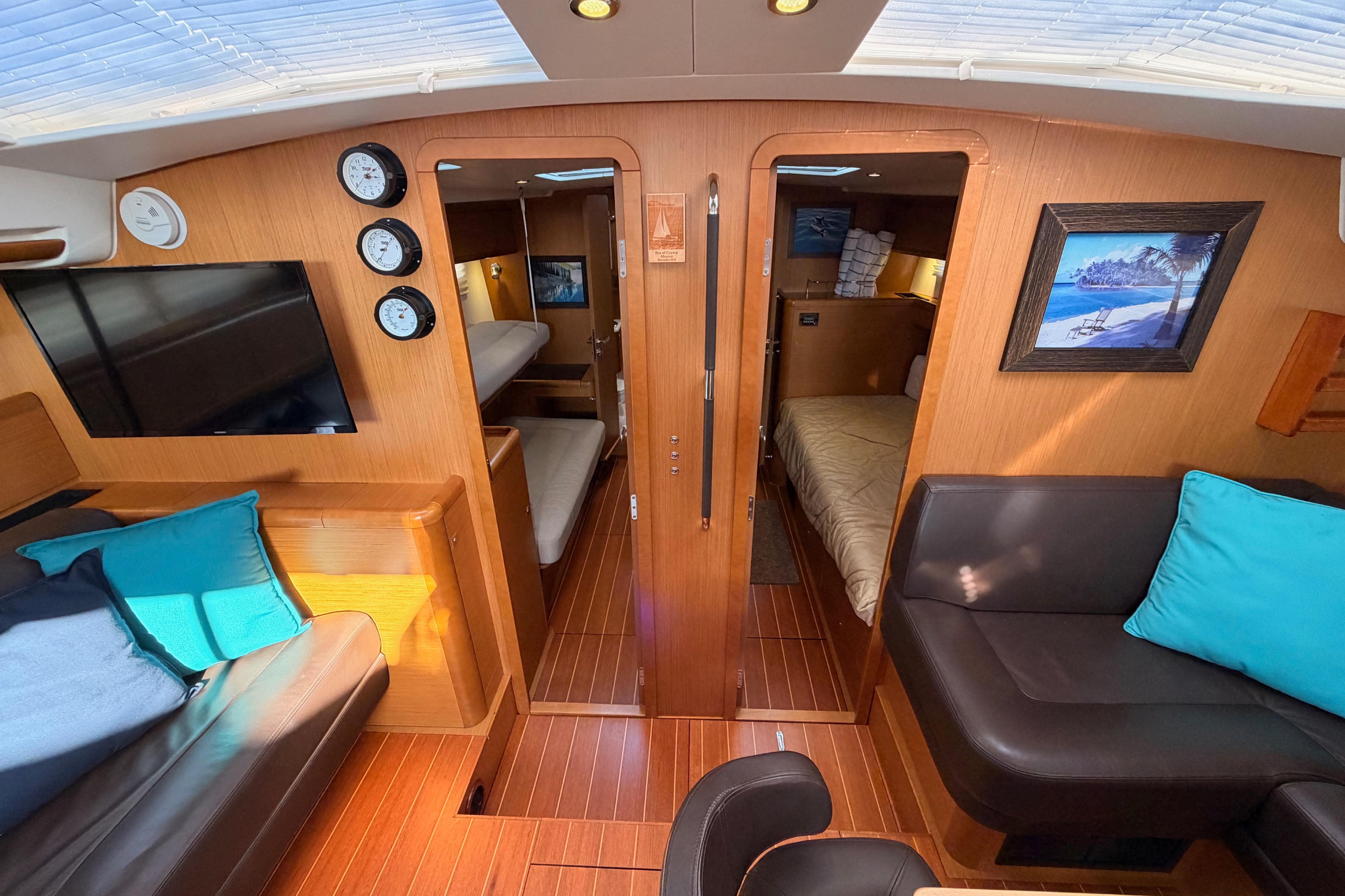 Interior of 2013 Jeanneau 57 yacht with cozy seating and elegant wood finish.