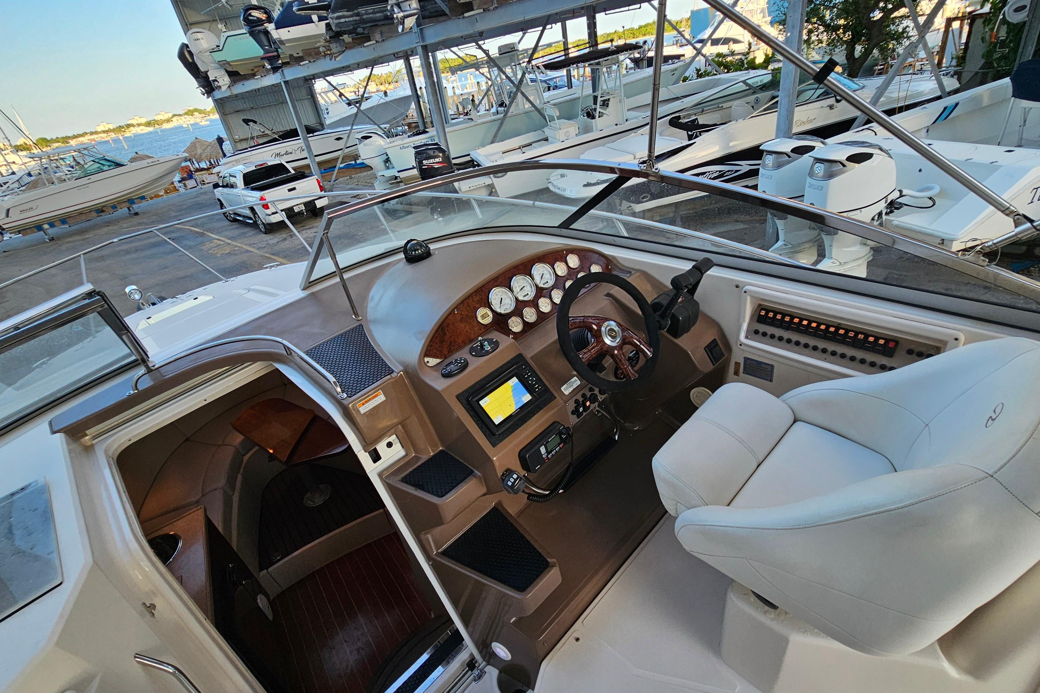 2005 Regal 3060 Window Express boat interior with helm, gauges, and seating at marina.