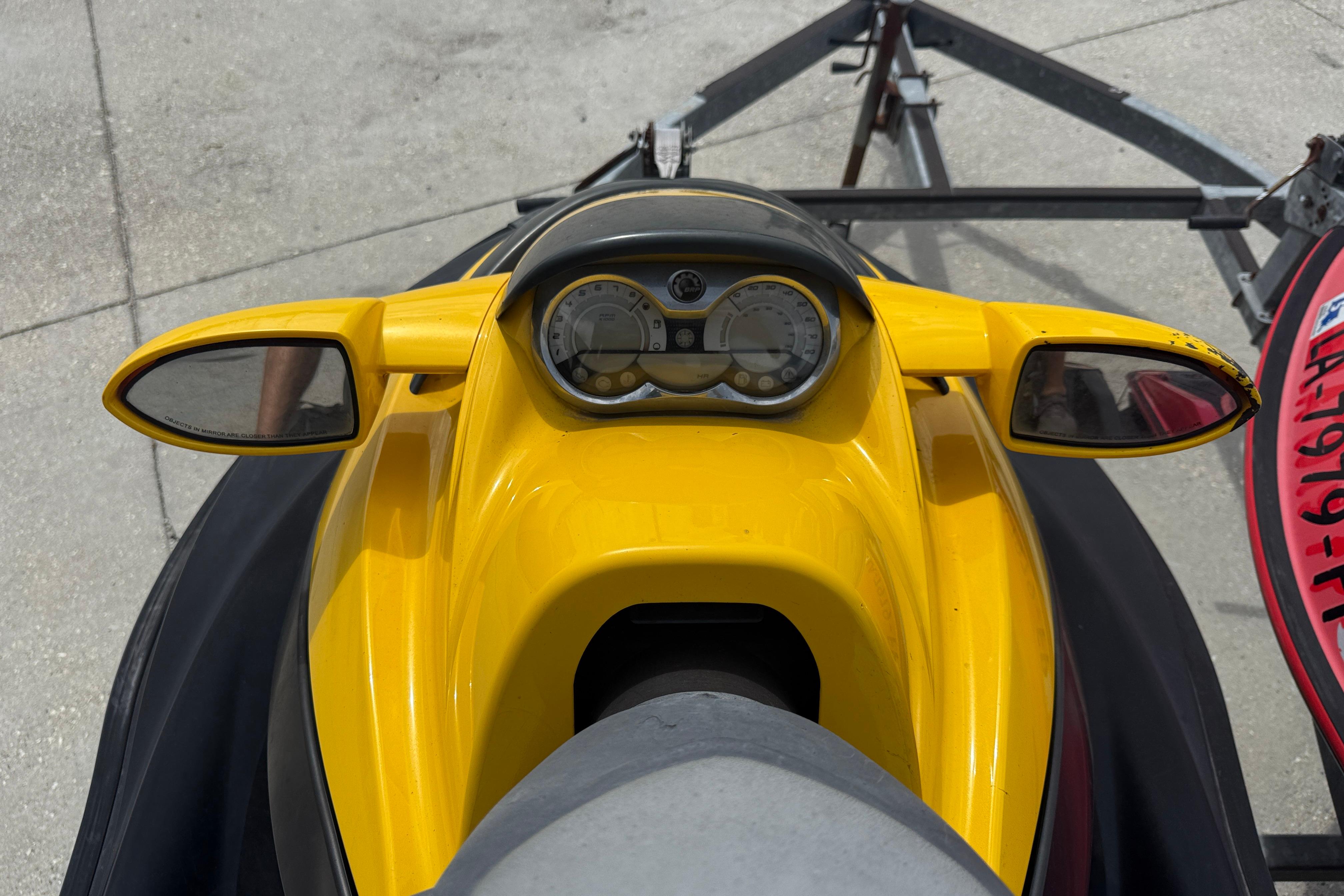 Yellow 2007 Sea-Doo RXT 215 jet ski dashboard with mirrors and gauges.