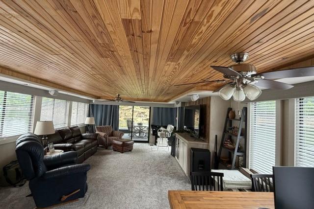 Spacious 1997 Stardust Houseboat interior with wood ceiling, cozy seating, and large windows.