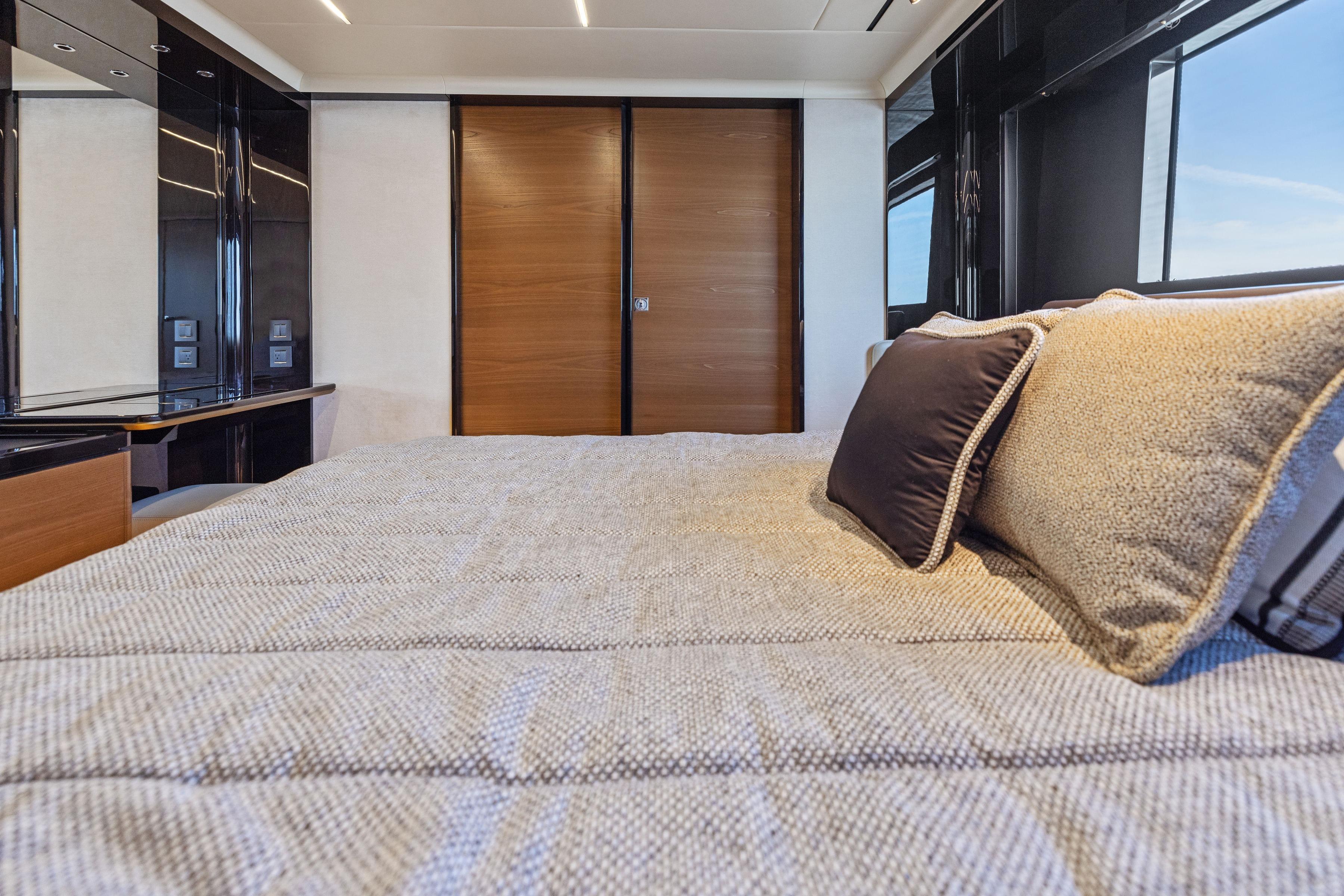 Luxurious bedroom interior of 2024 Absolute Navetta 64 yacht with elegant bedding and modern design.