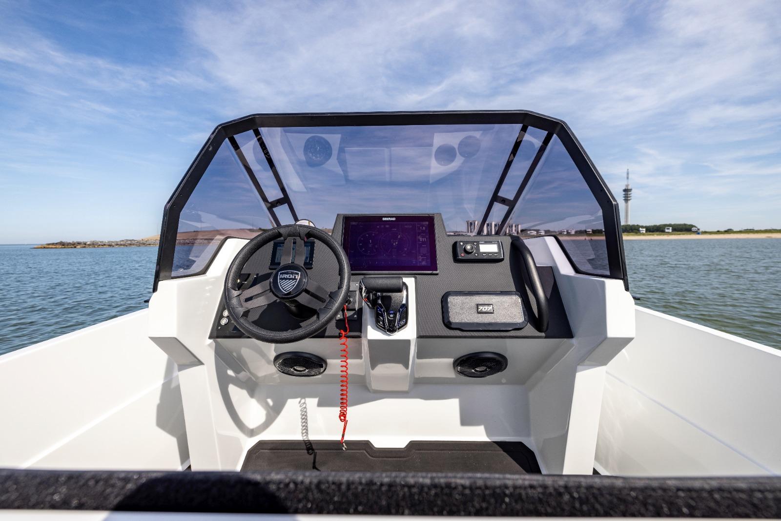Iron 707 boat dashboard with steering wheel and navigation system, 2022 model, on open water.