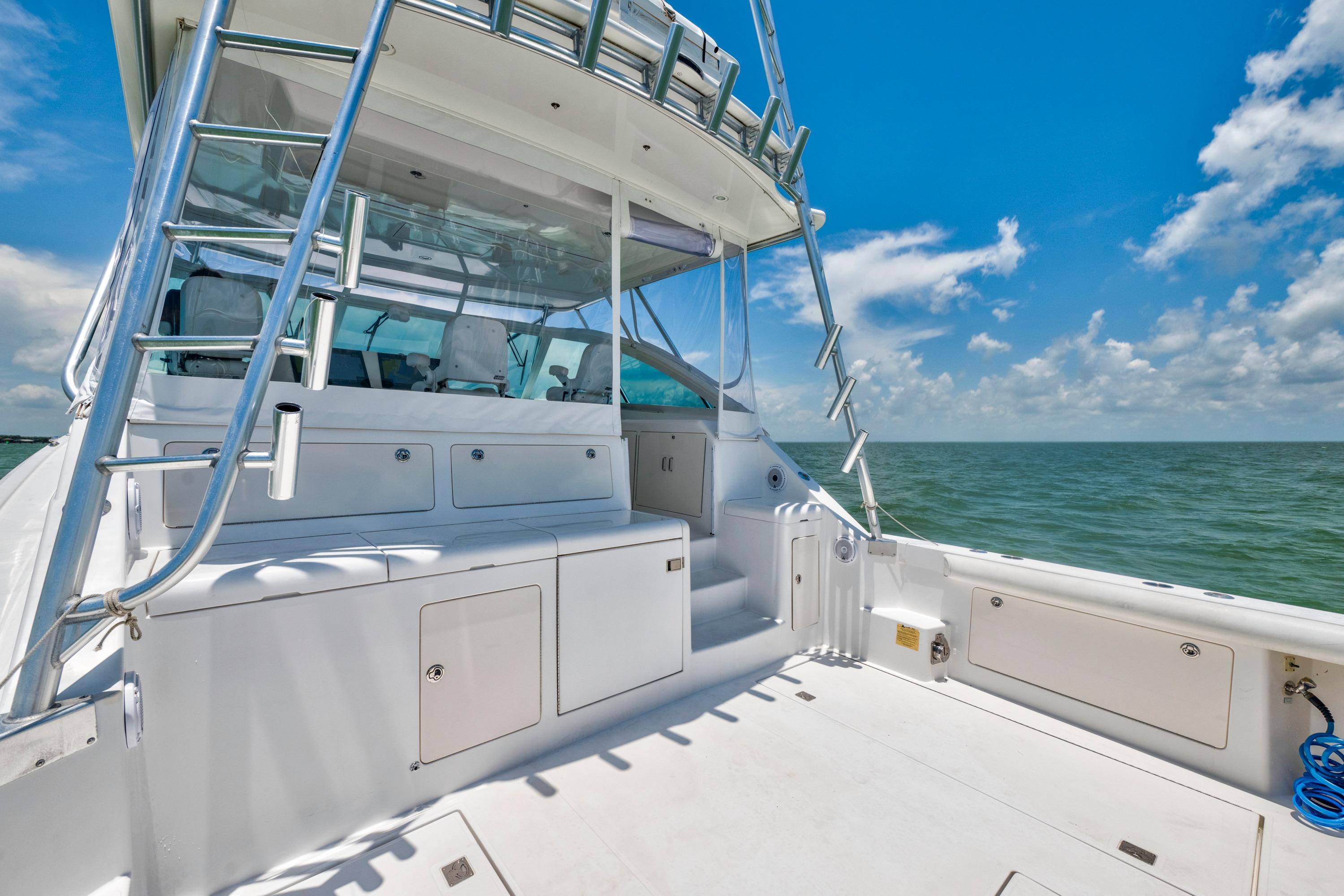 2010 Cabo 45 Express yacht deck with ocean view under clear blue sky.