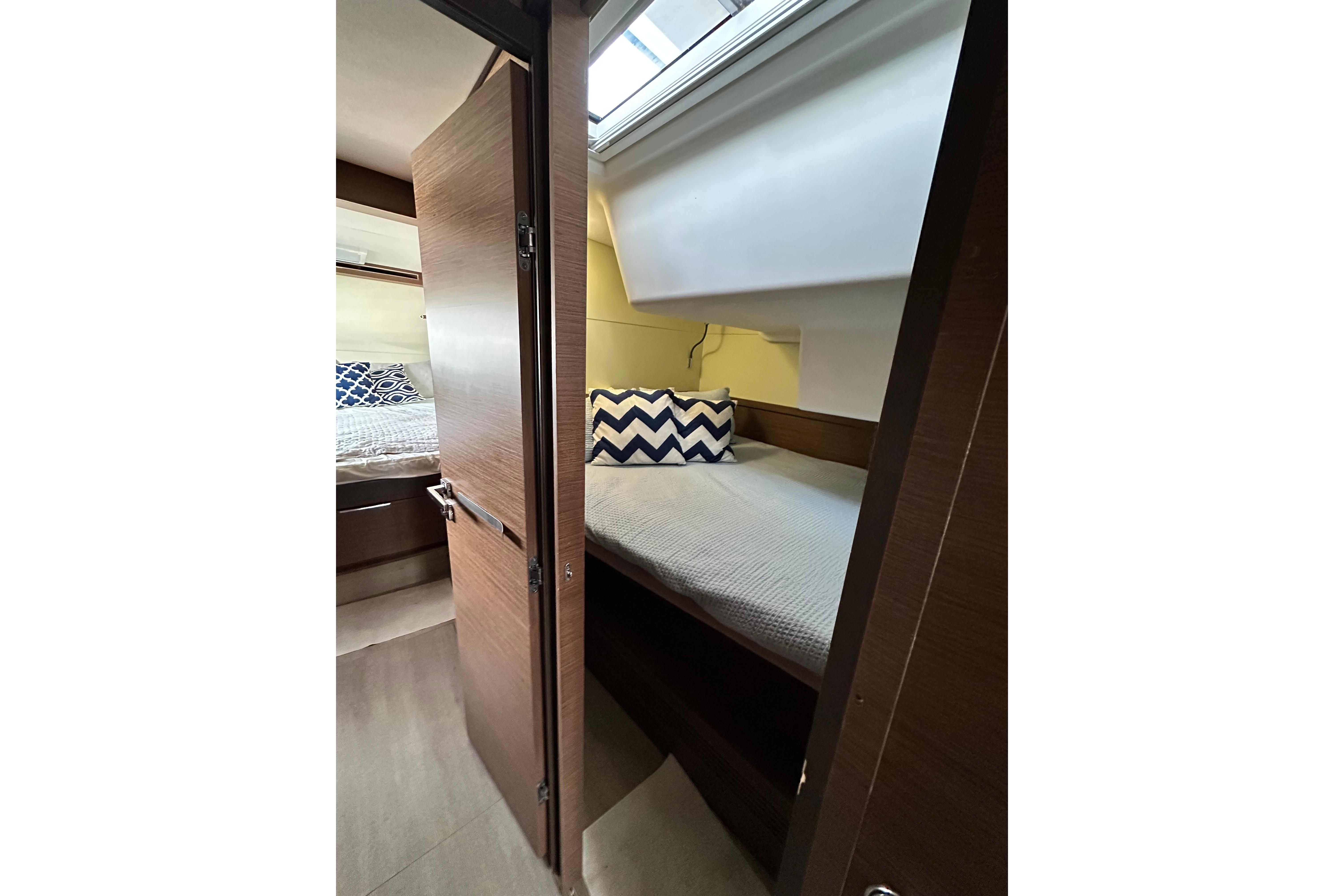 Interior of 2023 Lagoon 50 yacht, featuring cozy bed and pillow.