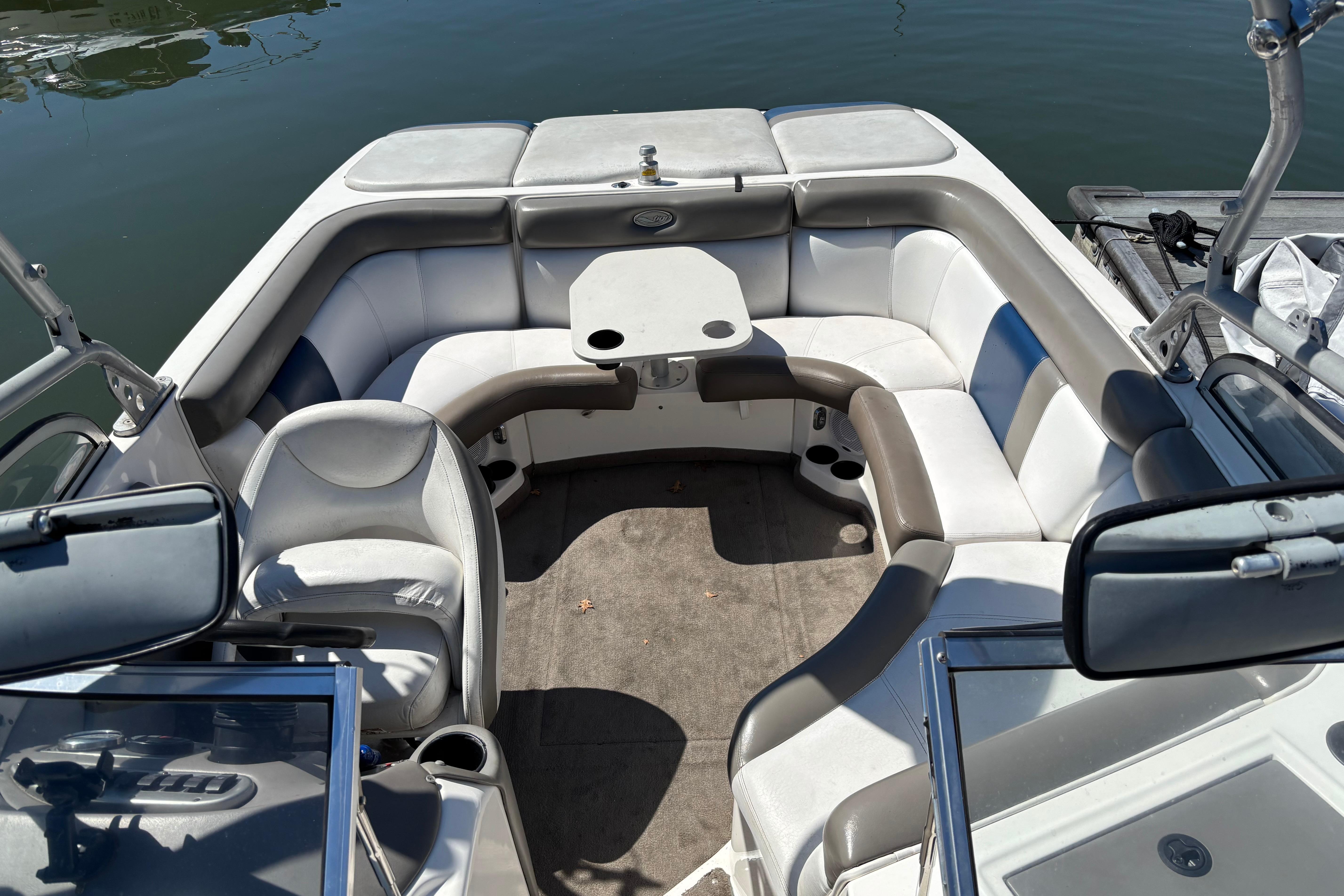 2004 Tigé 22V Limited Edition boat interior with seating and table on calm water.