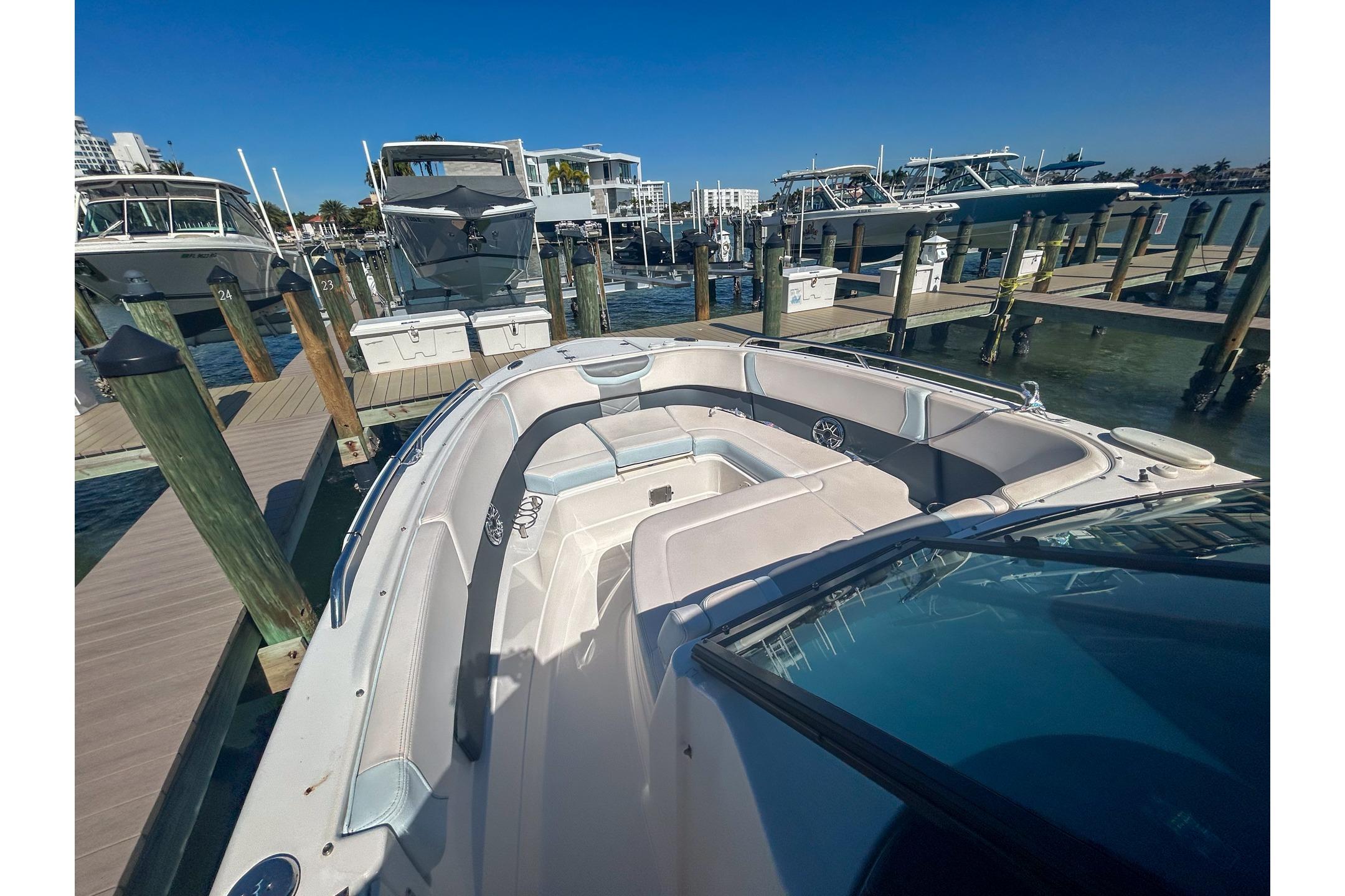 2021 Chaparral 280 OSX boat docked at marina, showcasing spacious seating area.