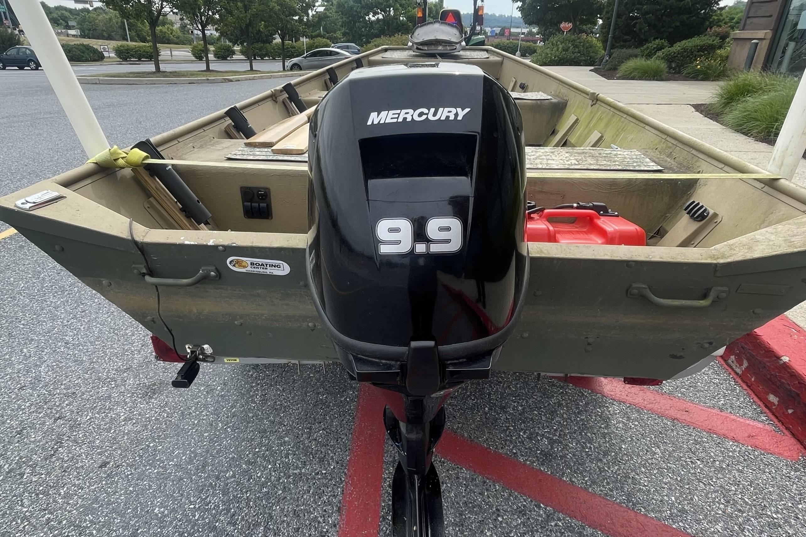 1986 Landau 1664 Jon boat with Mercury 9.9 outboard motor in parking lot.