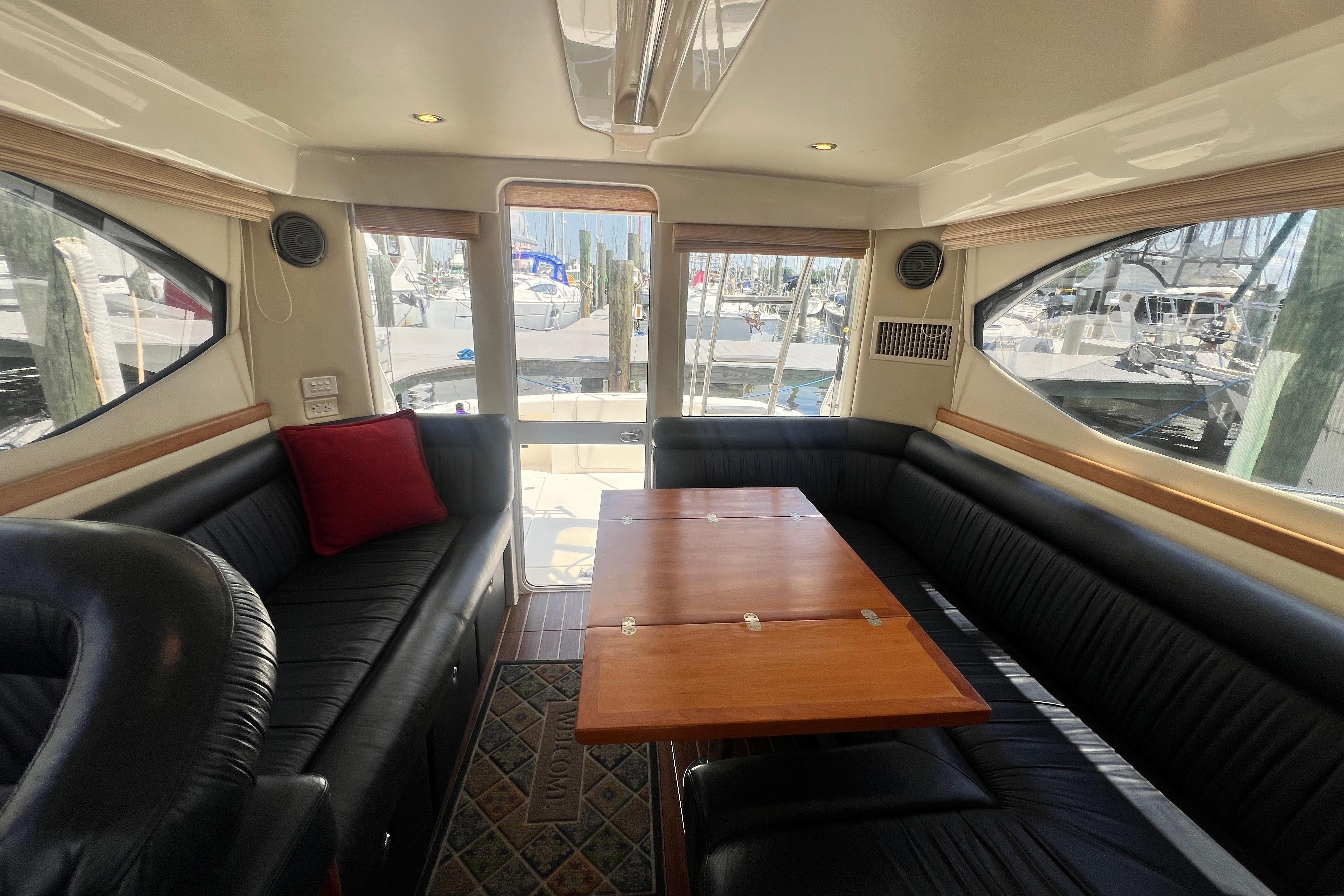 Luxurious interior of 2007 Riviera 33 Flybridge yacht with elegant seating and wooden table.