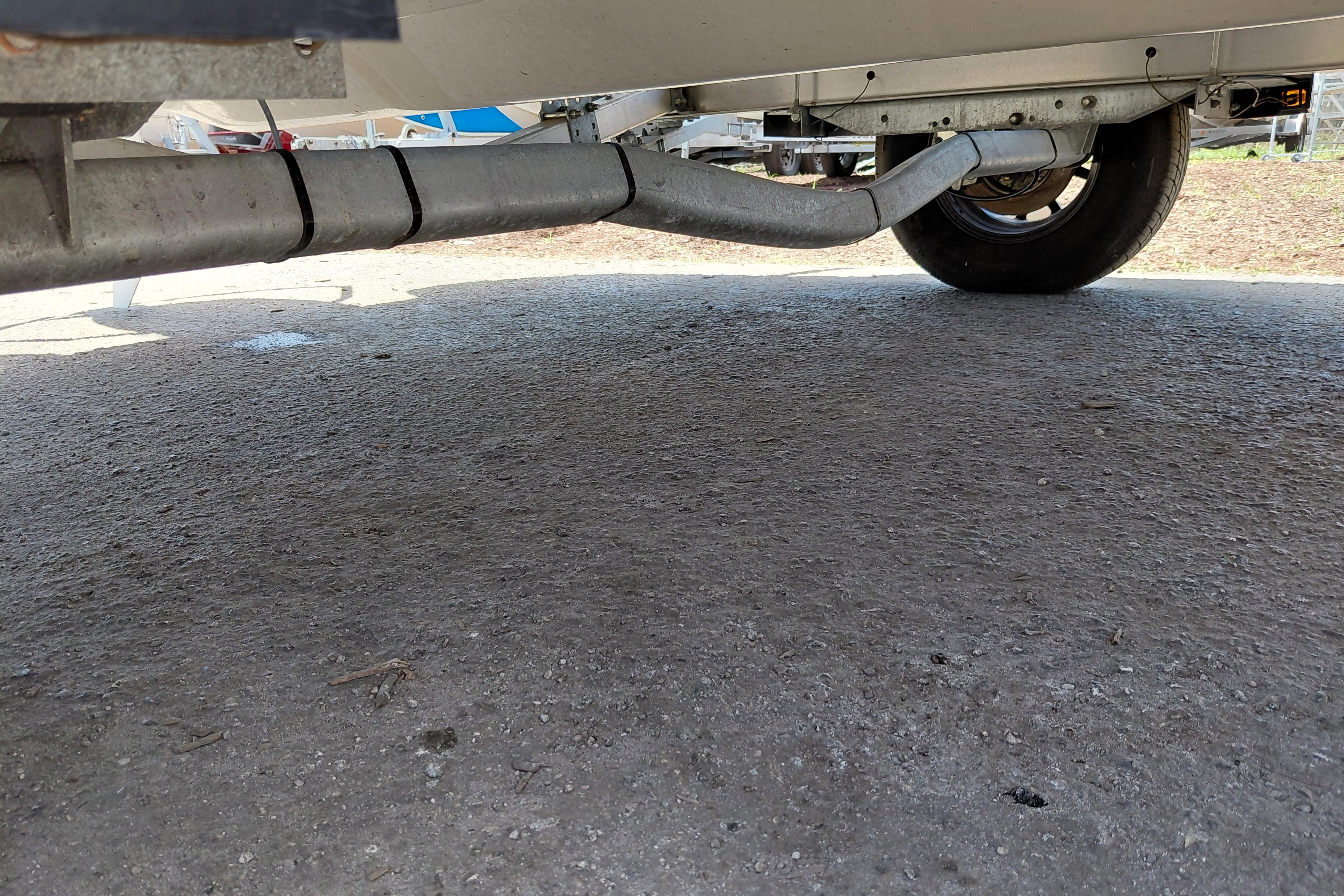 Underneath view of a 2023 Stingray 206 CC boat trailer on pavement.