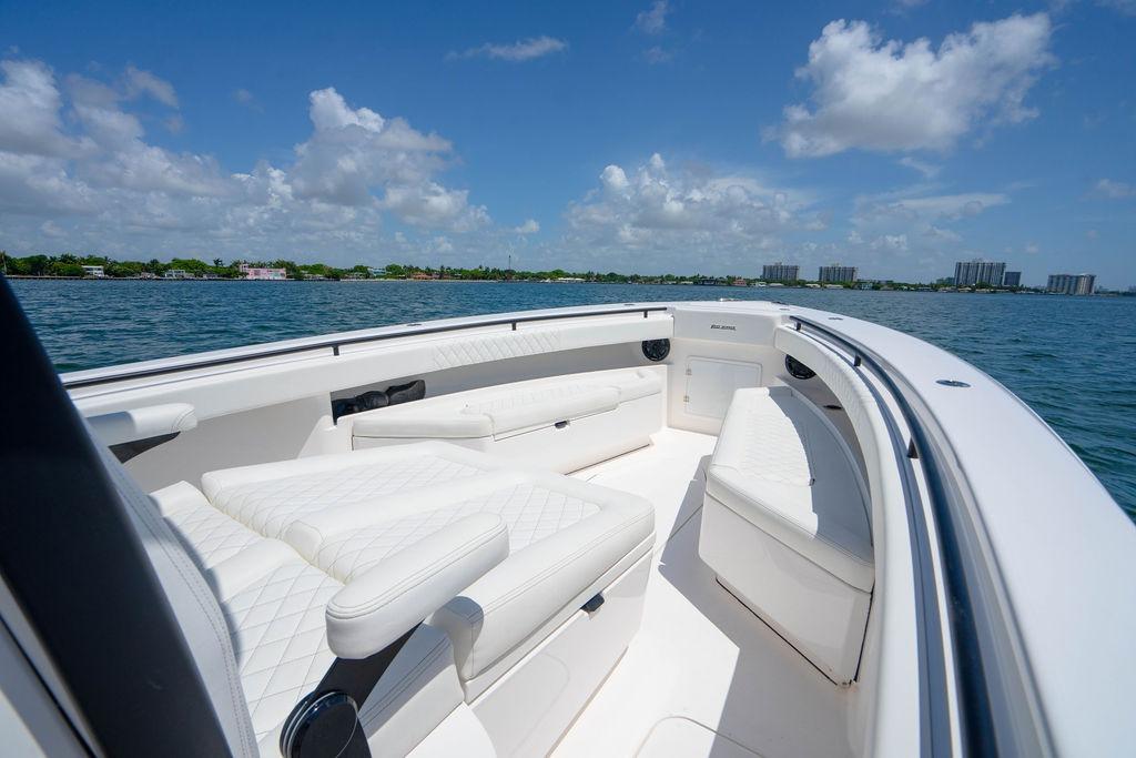Luxurious 2027 Reef Runner 340 boat with white seating, cruising on a sunny day.