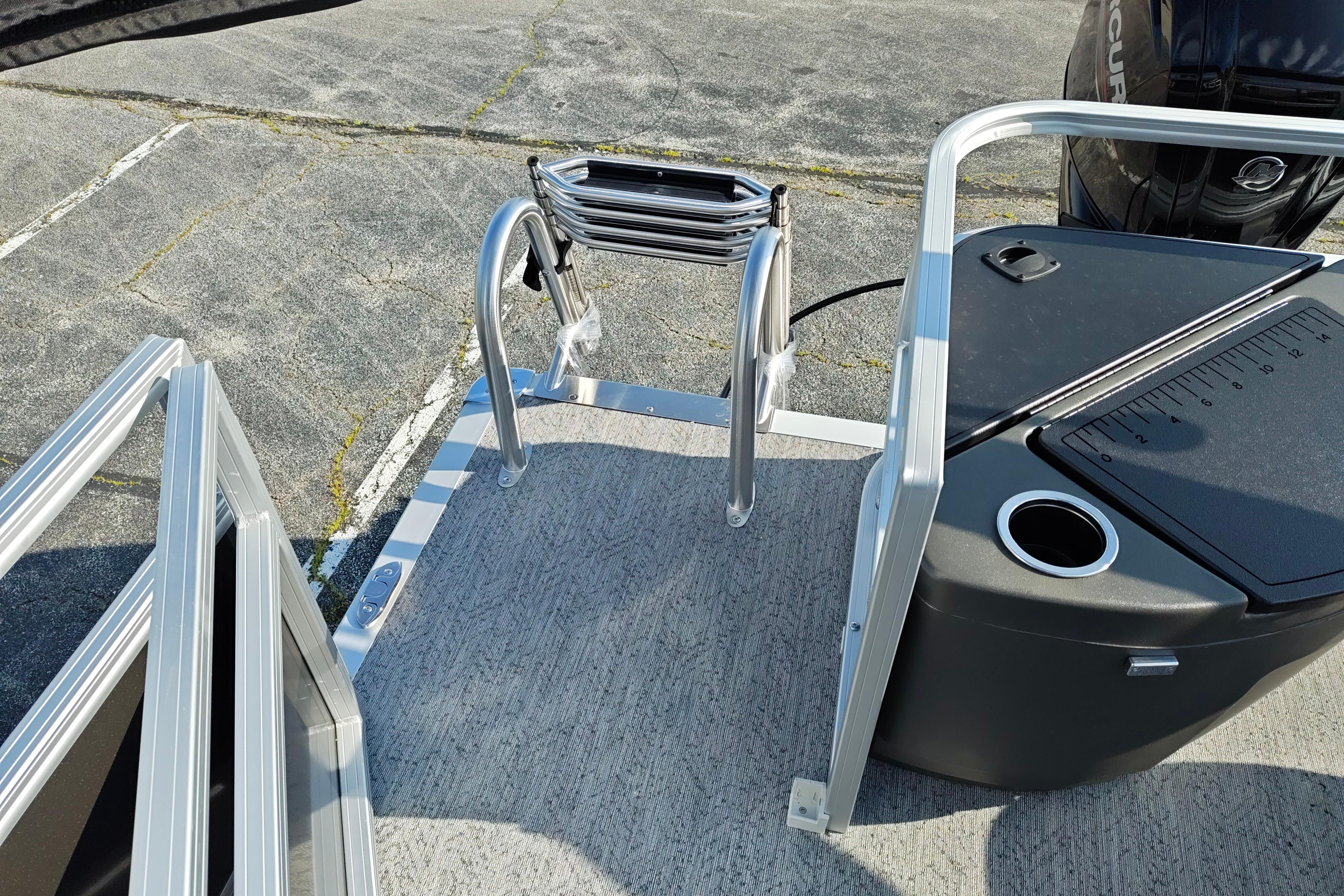 2026 Sun Tracker Bass Buggy 18 DLX boat ladder and deck area with motor.