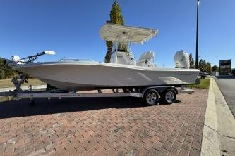 2025 Ranger 2510 Bay boat on trailer, parked on brick pavement under clear blue sky.