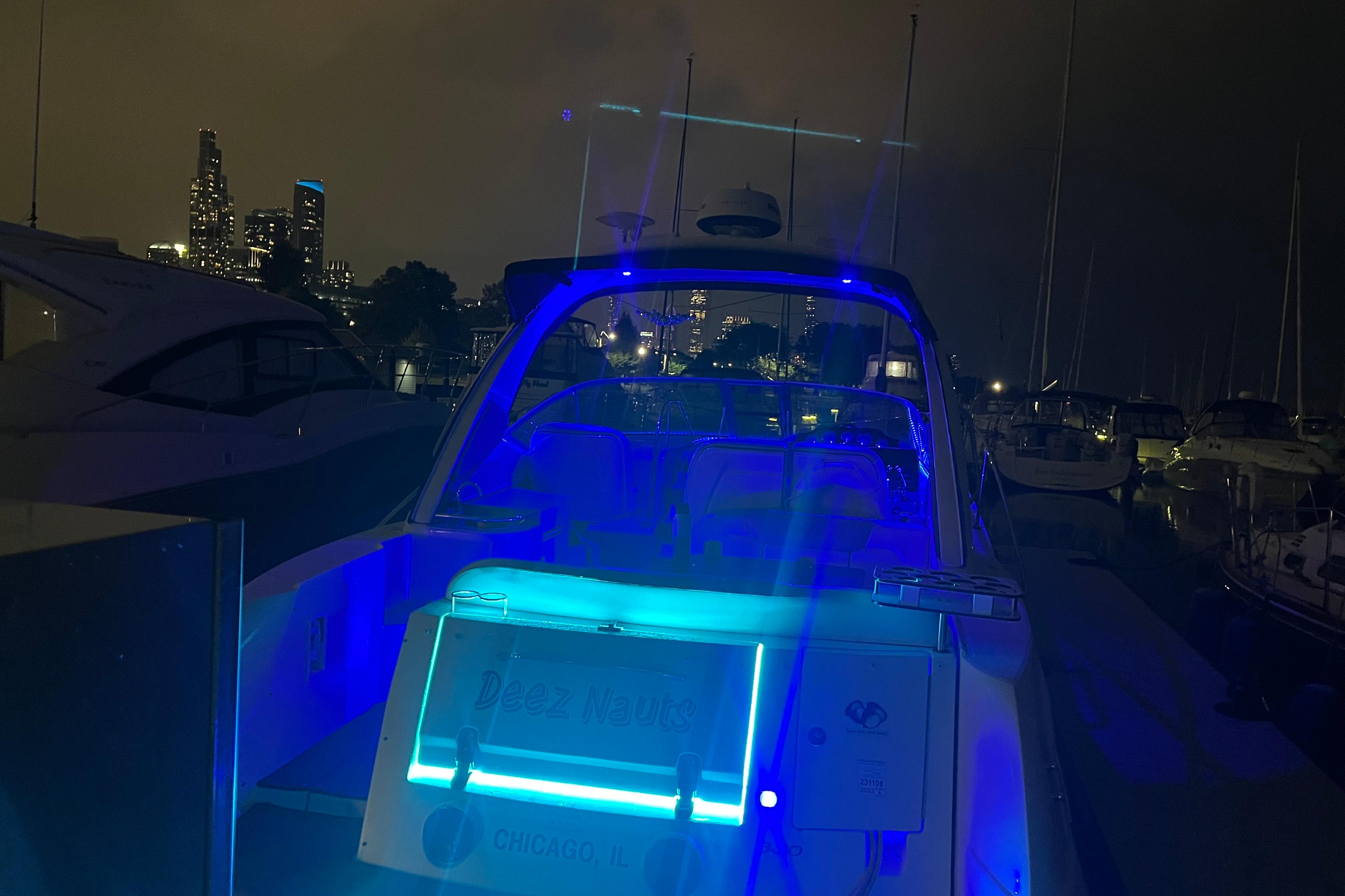 2008 Sea Ray 350 Sundancer yacht illuminated at night in Chicago marina.