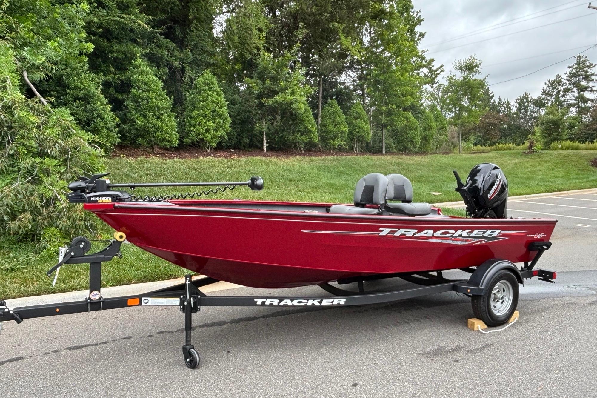 2025 Tracker Super Guide V-16 T boat on trailer, parked outdoors.