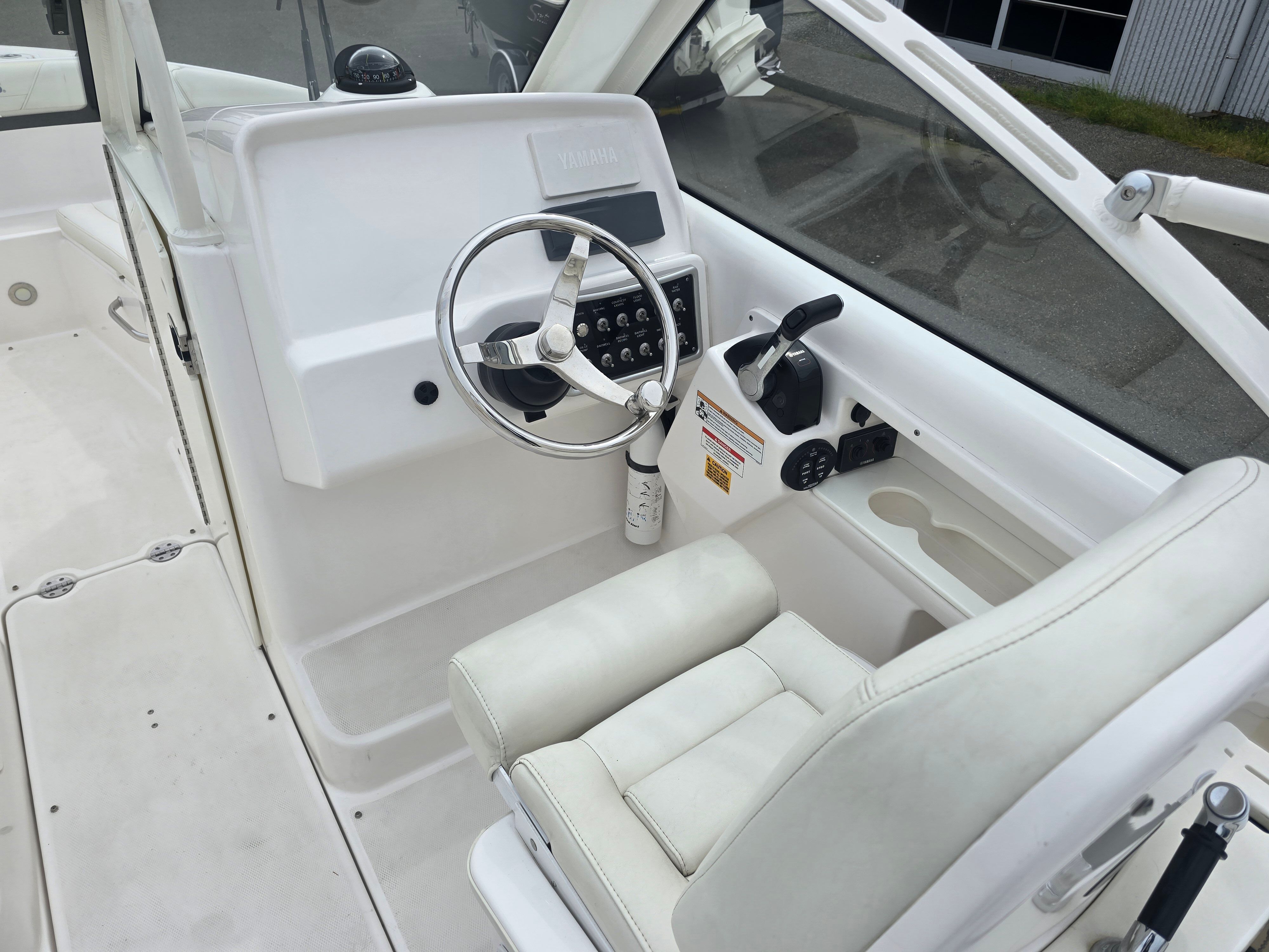 The image shows the cockpit of a 2017 Everglades 230 Dual Console boat with a white helm.