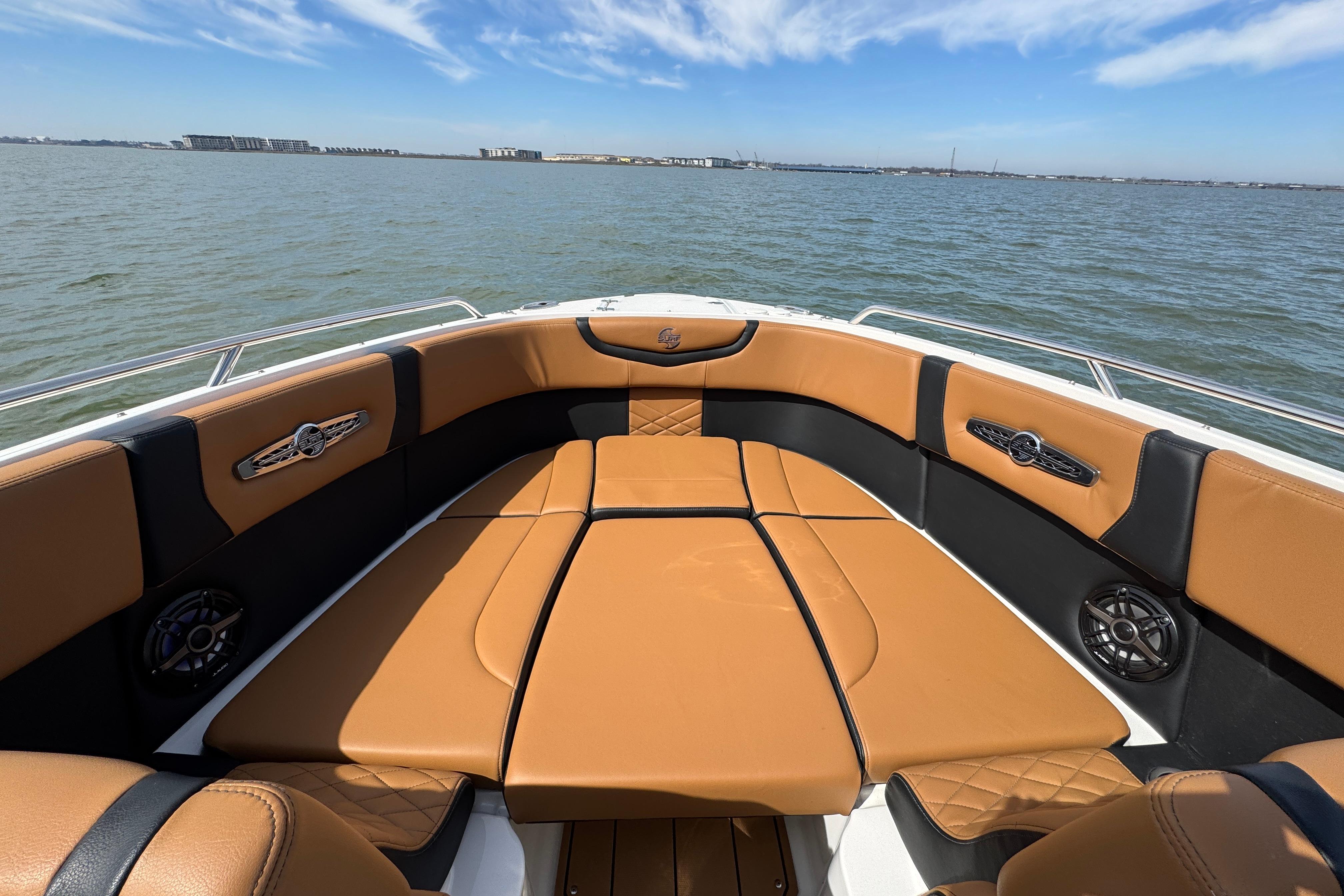Luxurious seating on 2023 Chaparral 26 Surf boat with scenic water view.