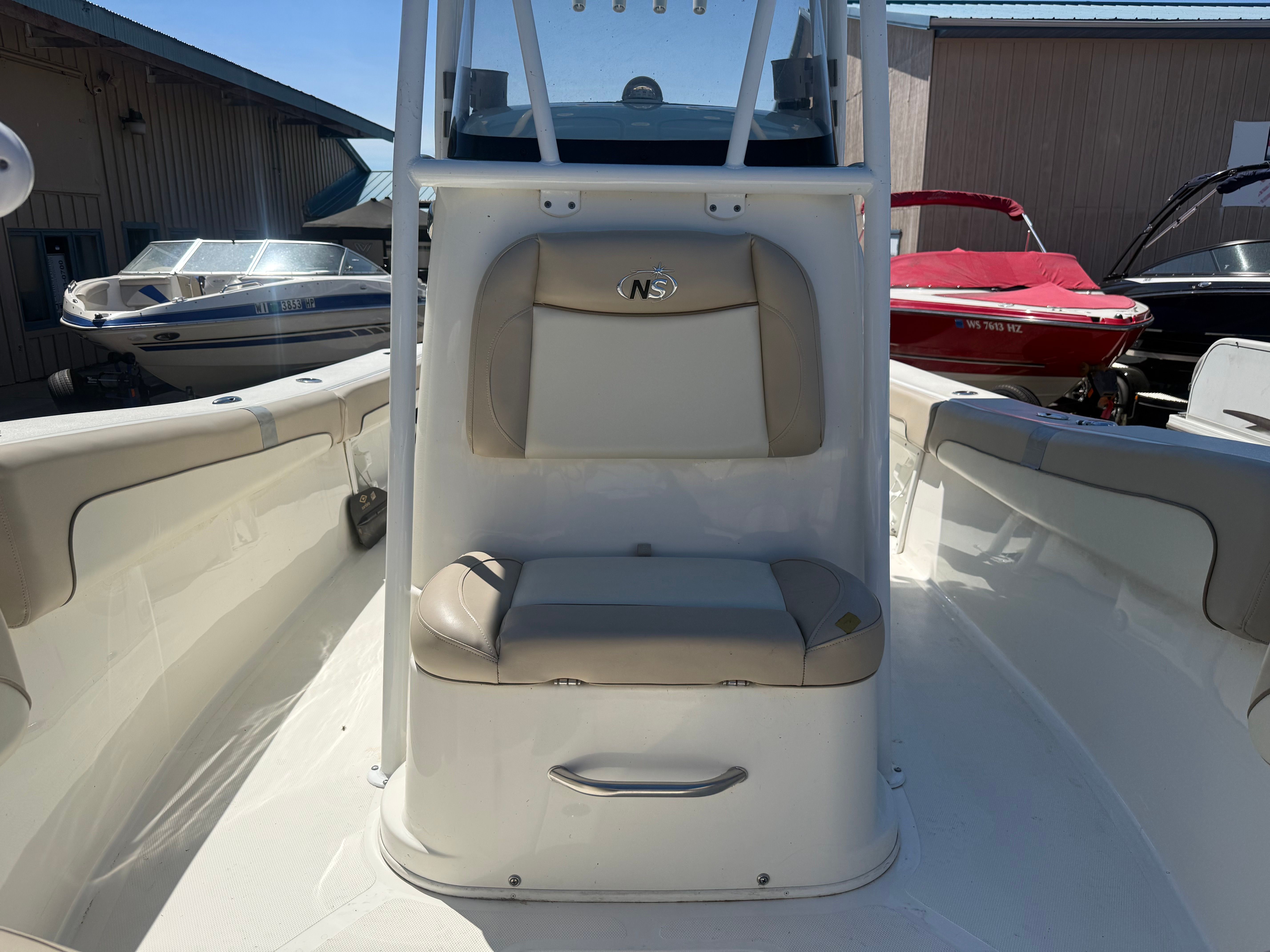 A NauticStar 22 XS boat with beige seating and console, surrounded by other boats.