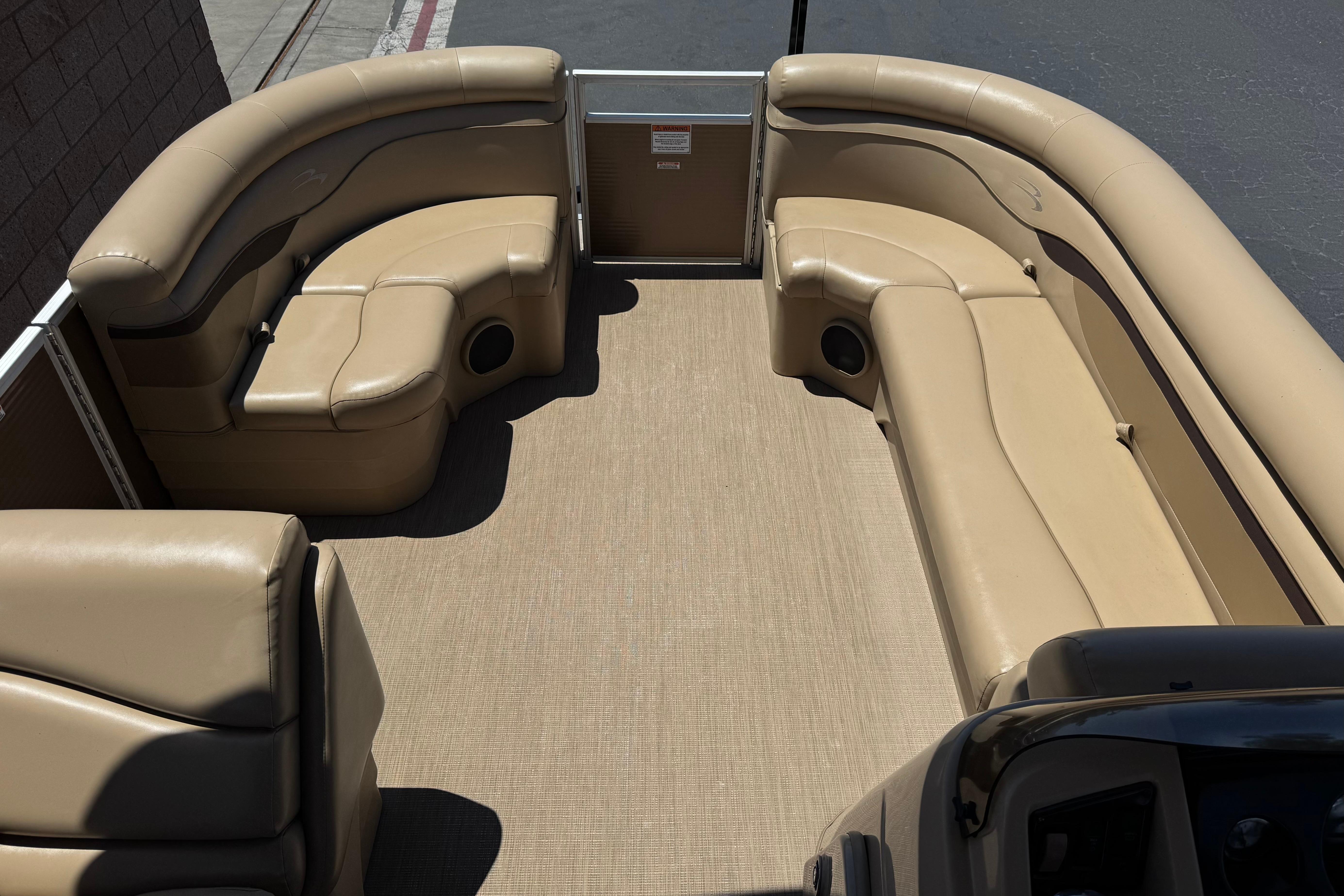 2018 Bennington 21 SSX pontoon boat interior with beige seating and spacious layout.