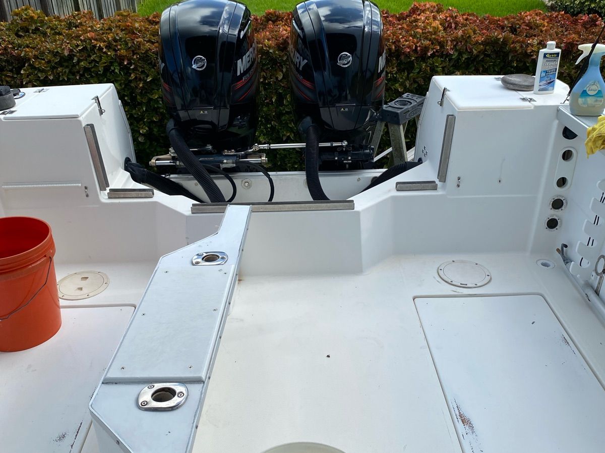 Rear view of a 1990 Bayliner 2302 Trophy with dual outboard motors.