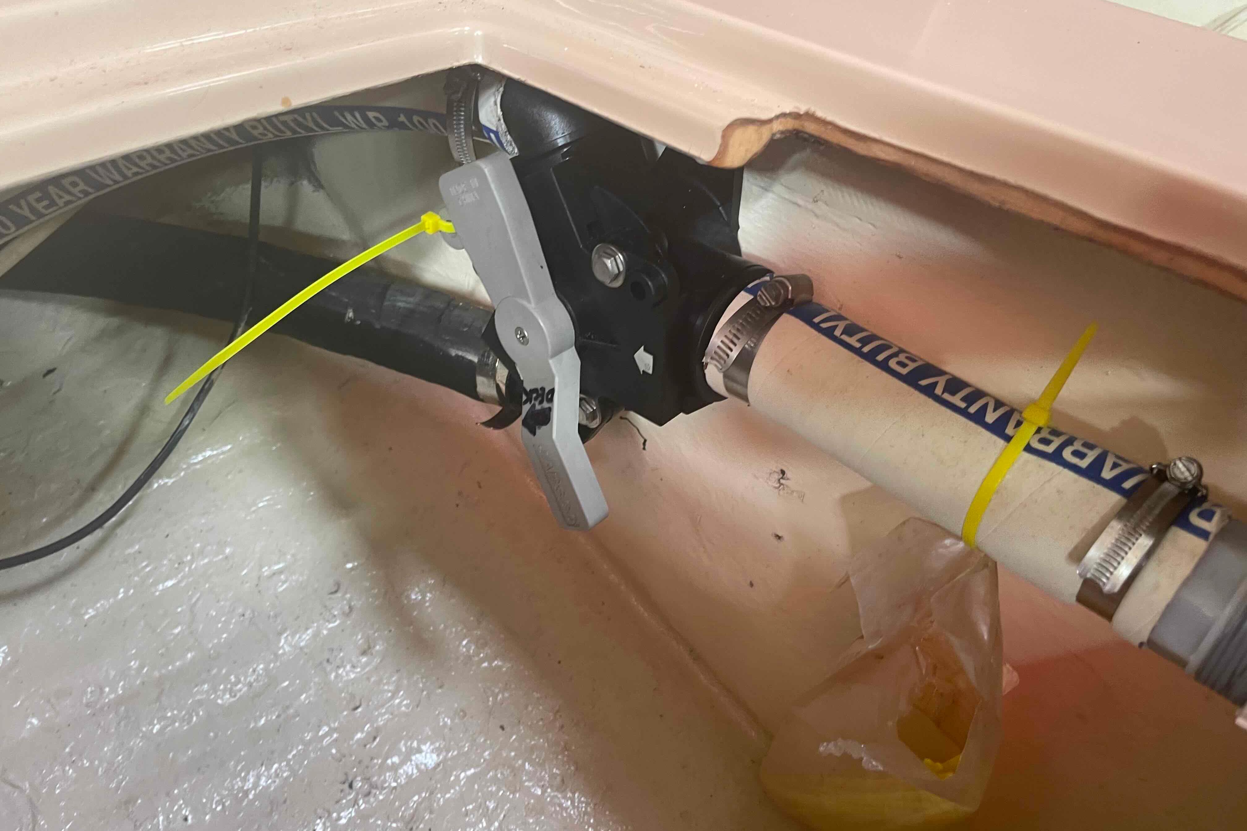 Plumbing system in 1989 Island Packet 35 sailboat, featuring pipes and valve connections.