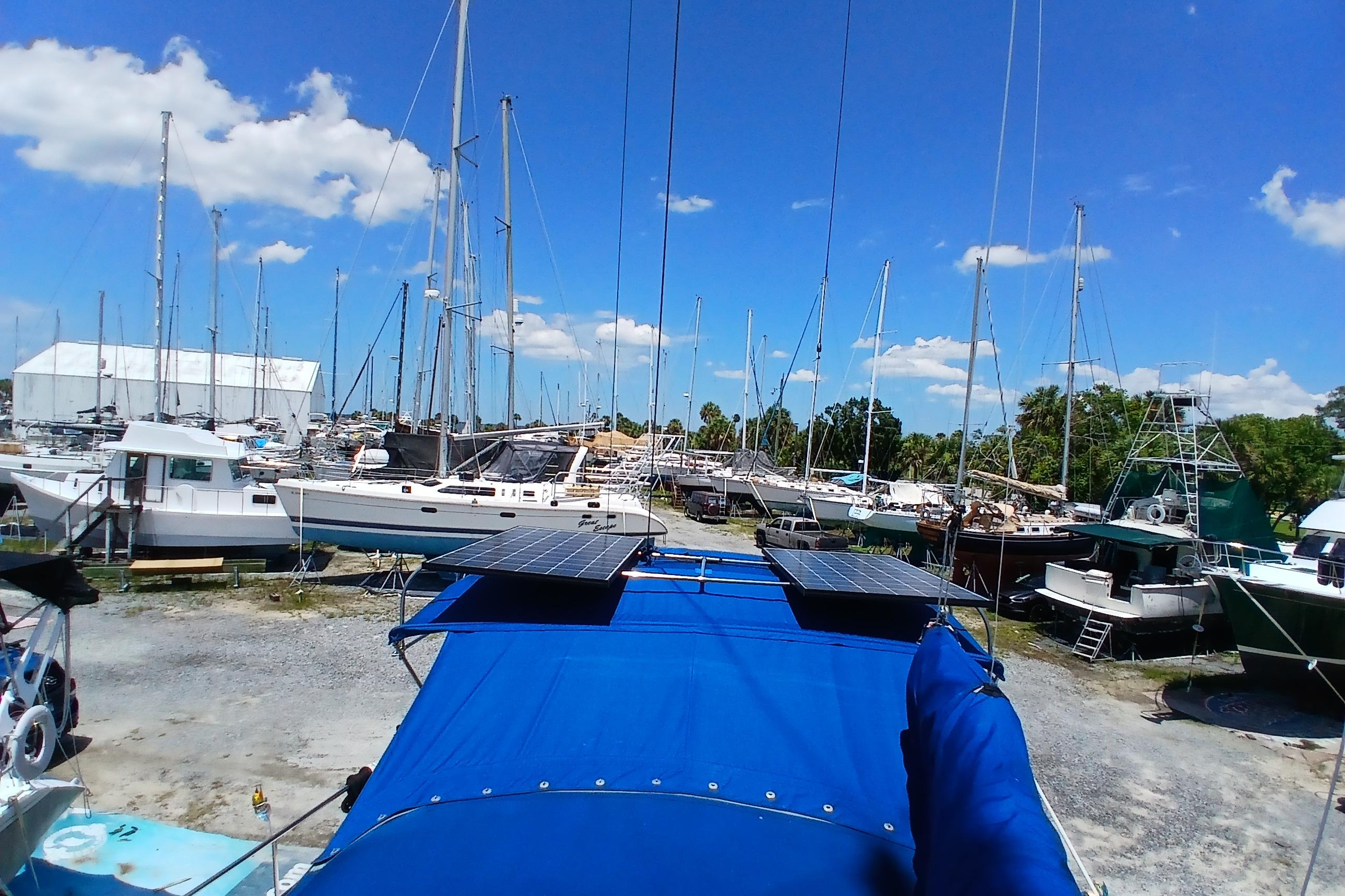Boatyard with Catalina 42 MkII sailboats, solar panels, and clear blue sky.