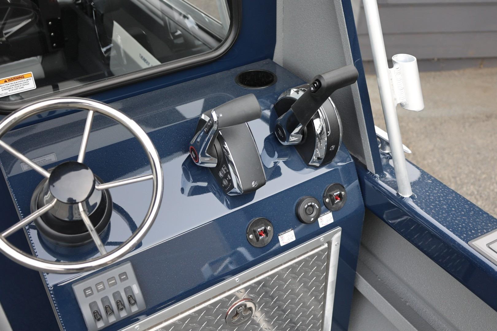 Control panel of 2026 Thunder Jet 24 Alexis Pro boat with steering wheel and throttle levers.