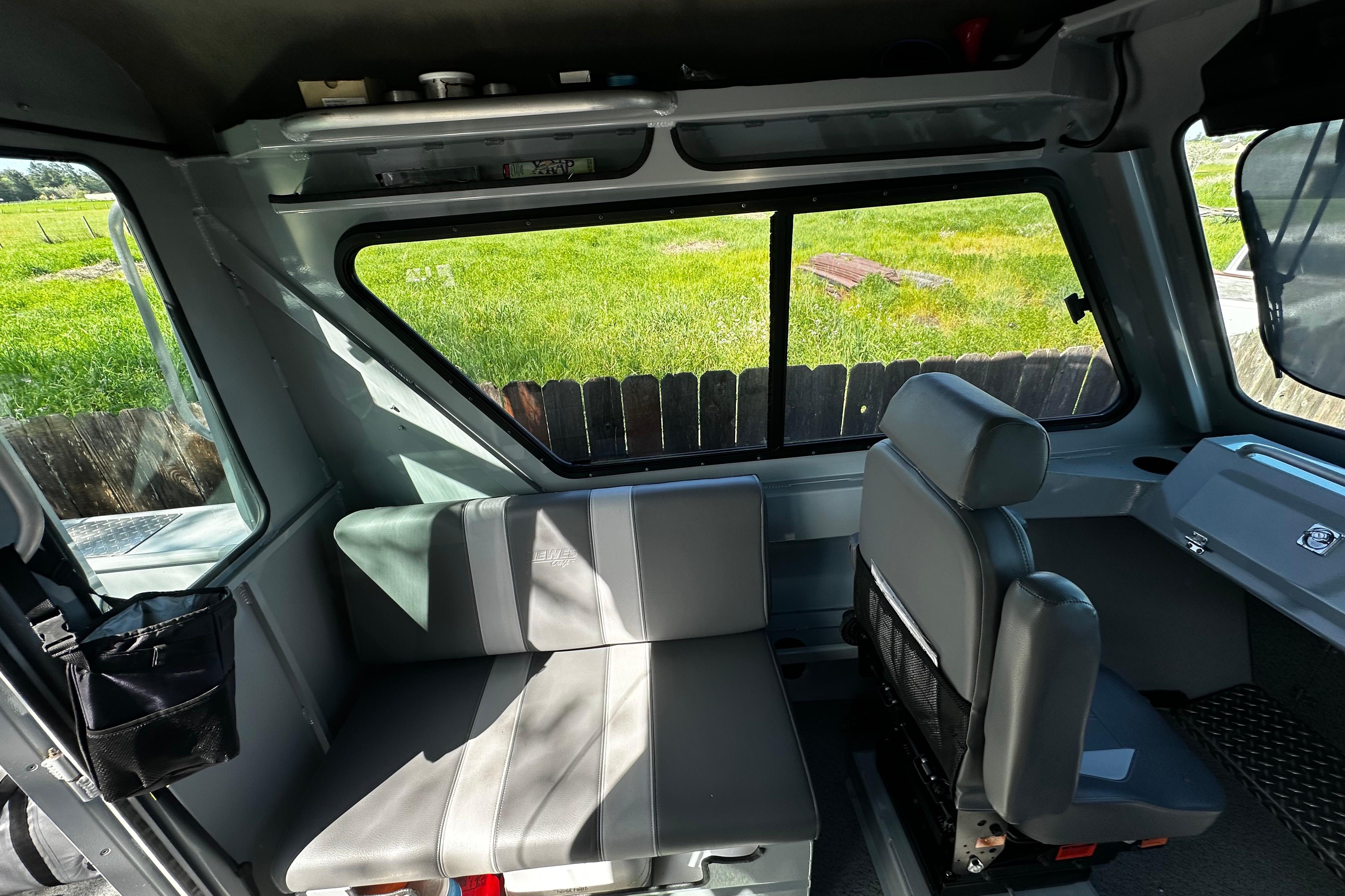 Interior of 2022 Hewescraft 220 Ocean Pro ET Hardtop, featuring seating and windows.