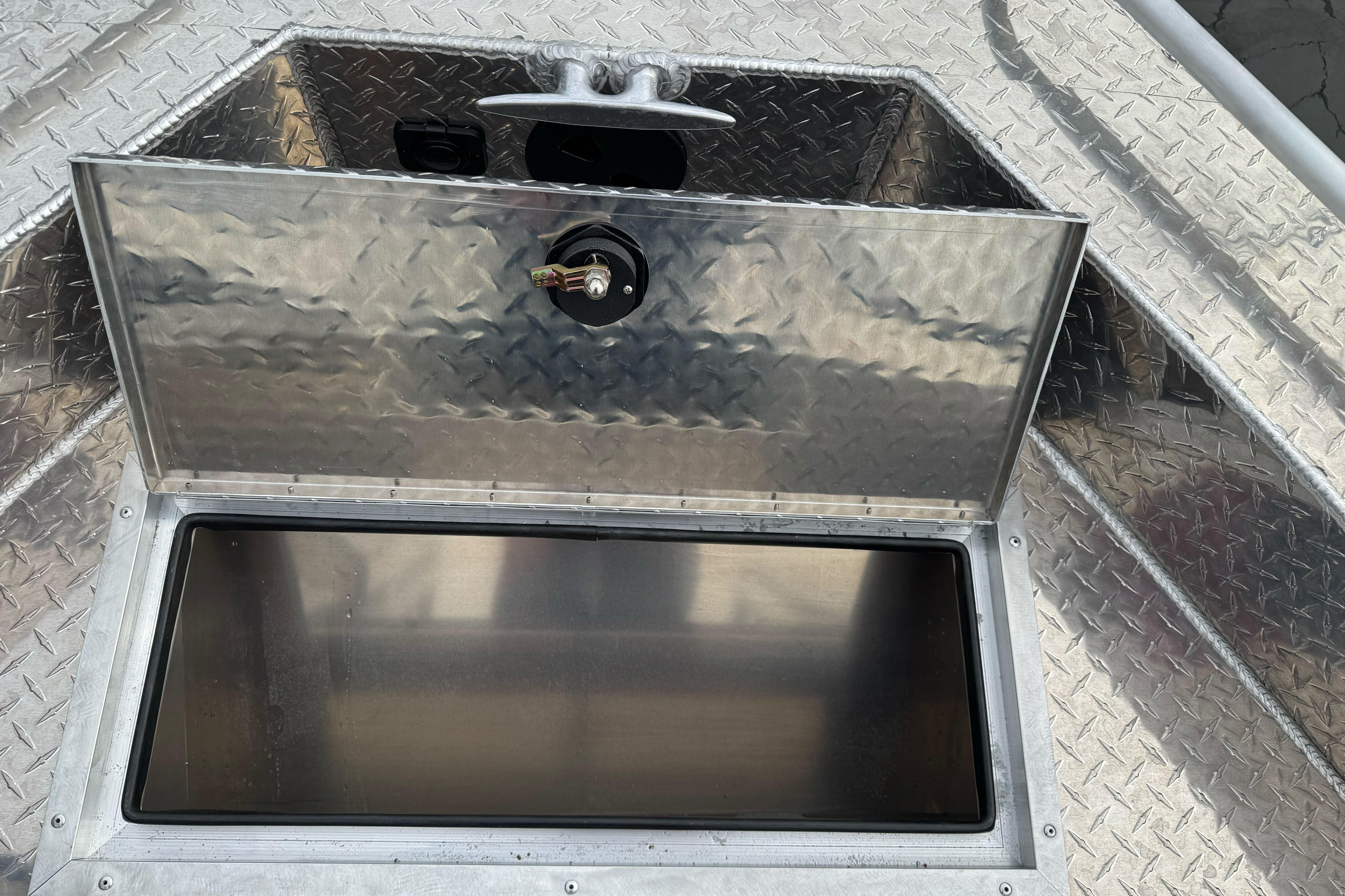 Open storage compartment on 2026 Lund 185 Heavy Gauge boat with diamond plate finish.