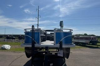 2026 Sun Tracker Fishin' Barge 20 DLX pontoon boat on display under a clear blue sky.
