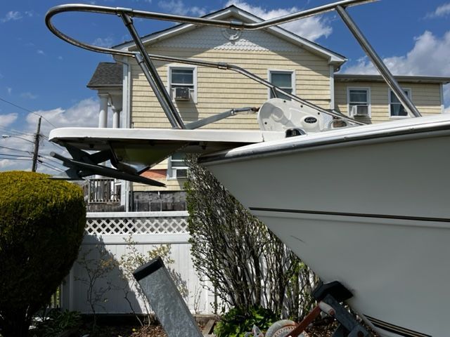 A 1998 Sport-Craft 252 Sport Fish boat is positioned in front of a house. The bow faces right.