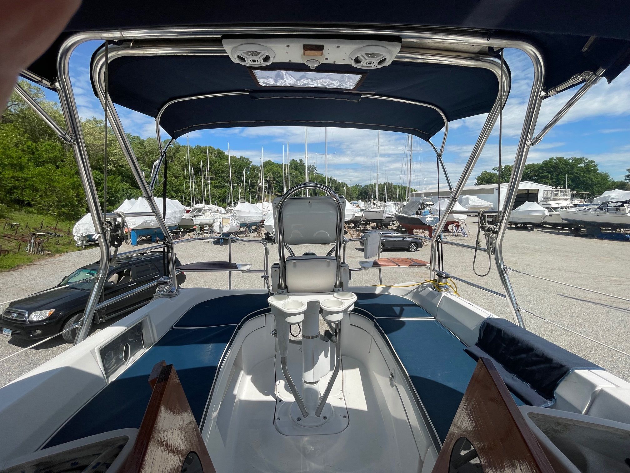 The cockpit of a Hunter 33 yacht with blue cushions and a steering wheel.